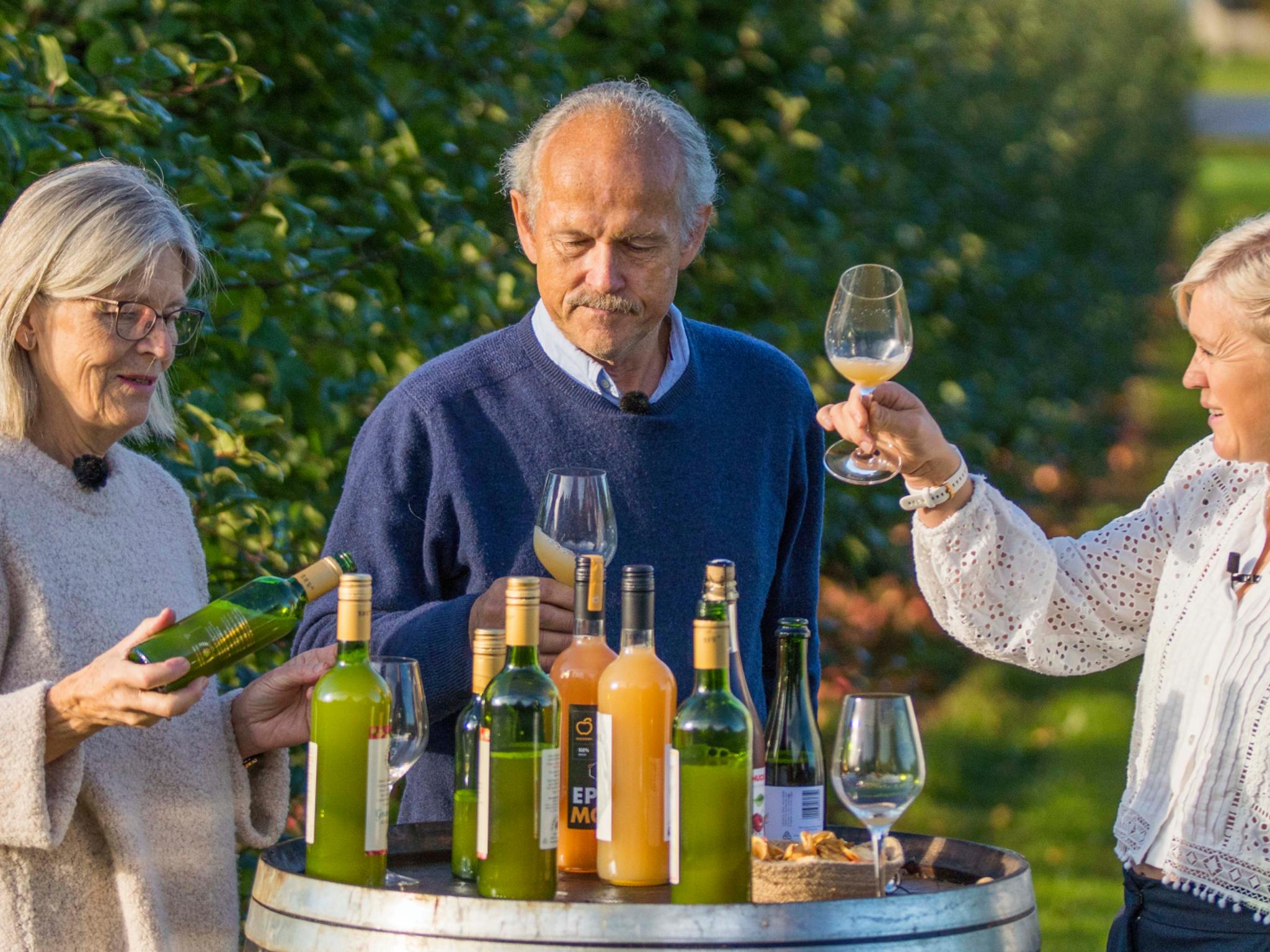 Three people tasting apple juice made of Aroma apples in the Fruit Village