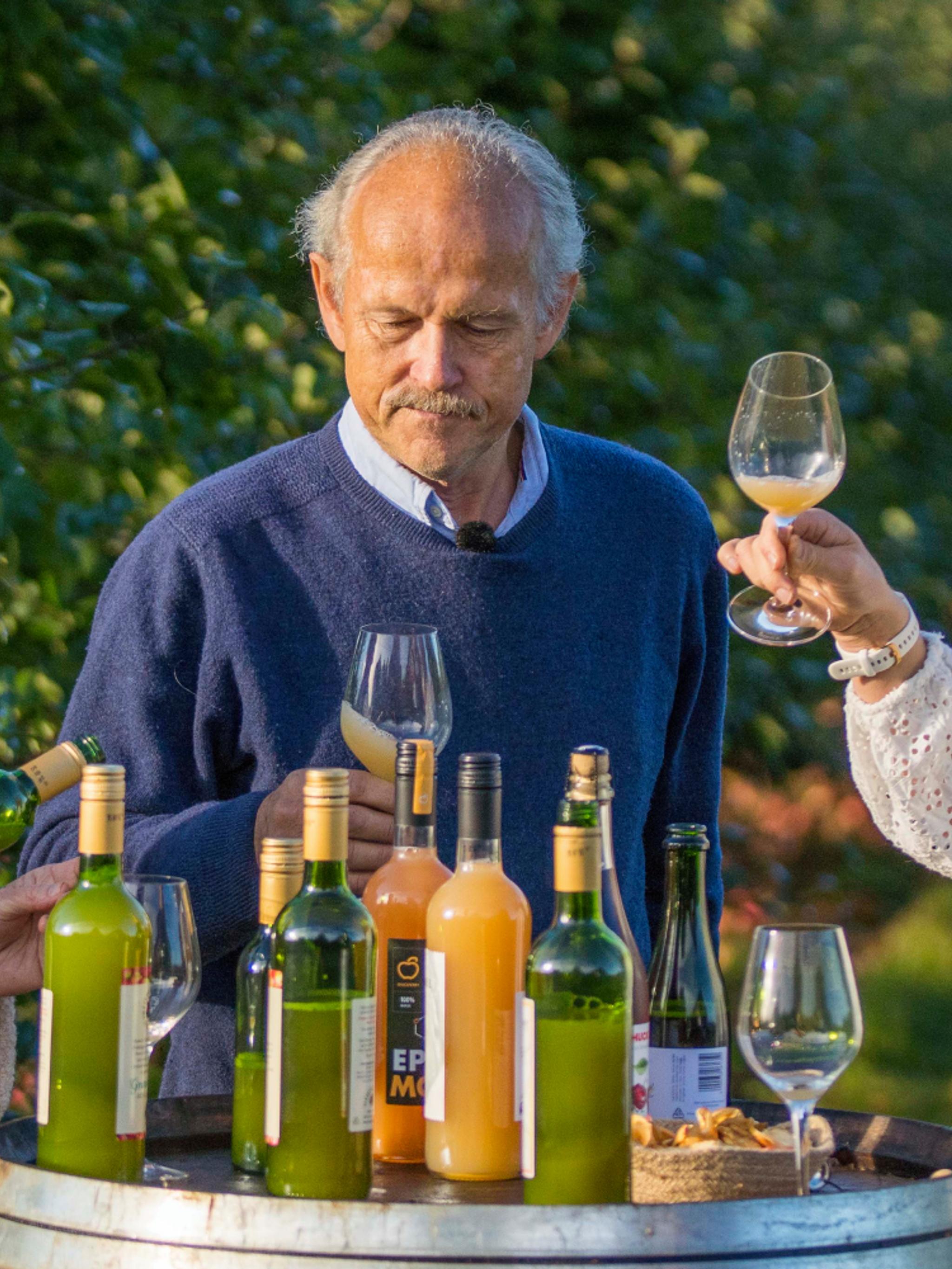 Three people tasting apple juice made of Aroma apples in the Fruit Village