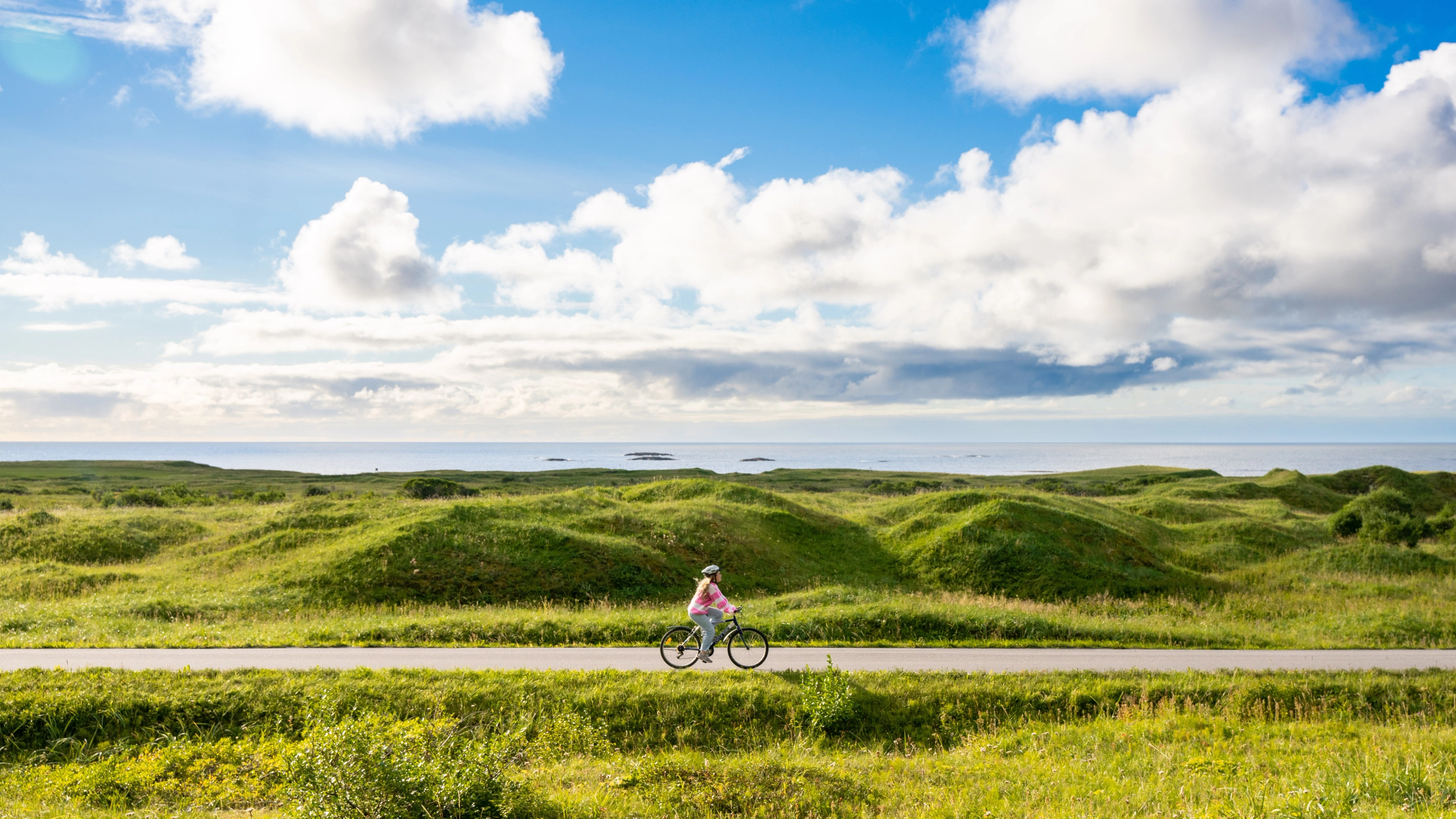 Woman biking the Norwegian Scenic Route at Andøya