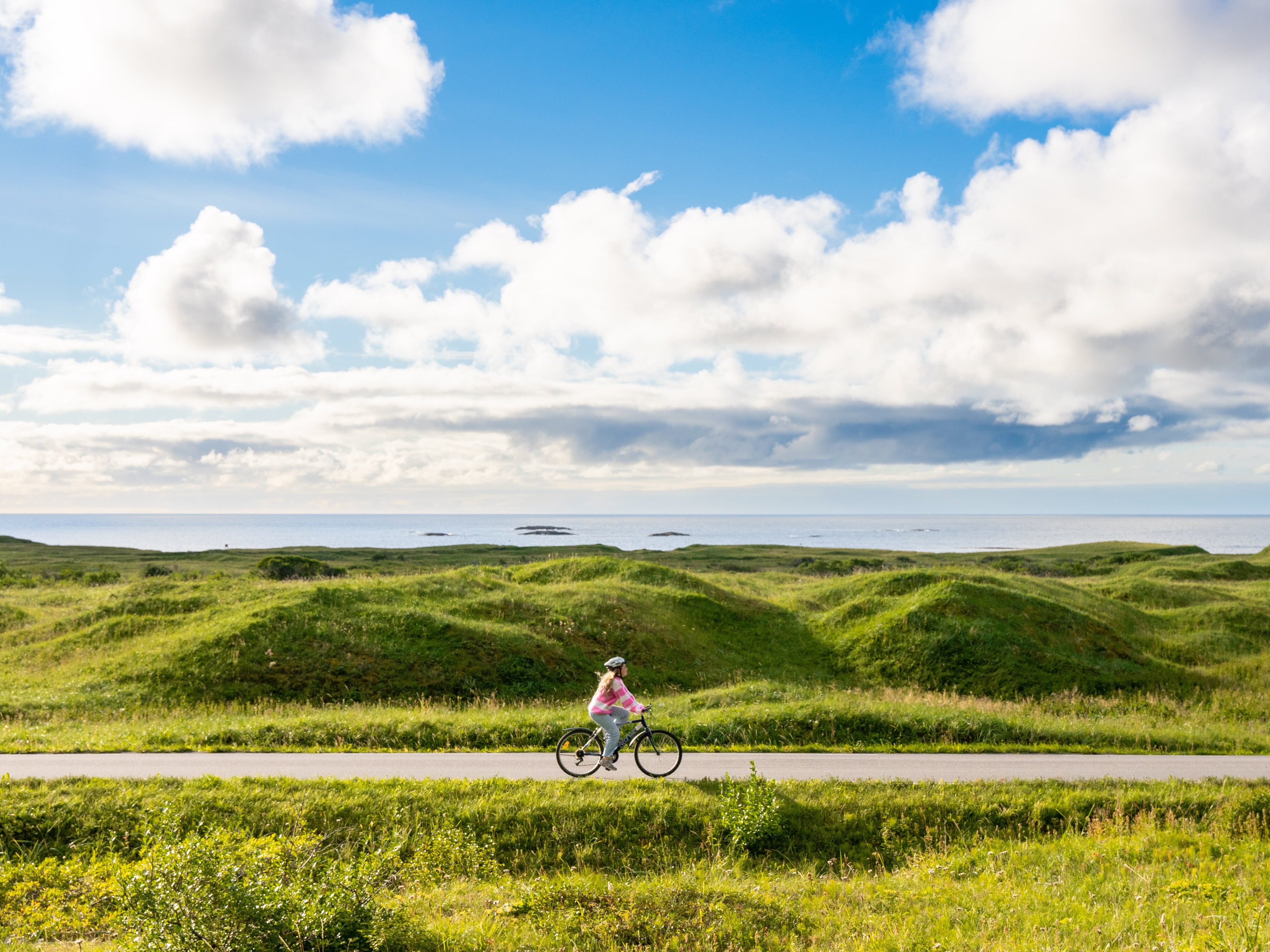 Woman biking the Norwegian Scenic Route at Andøya