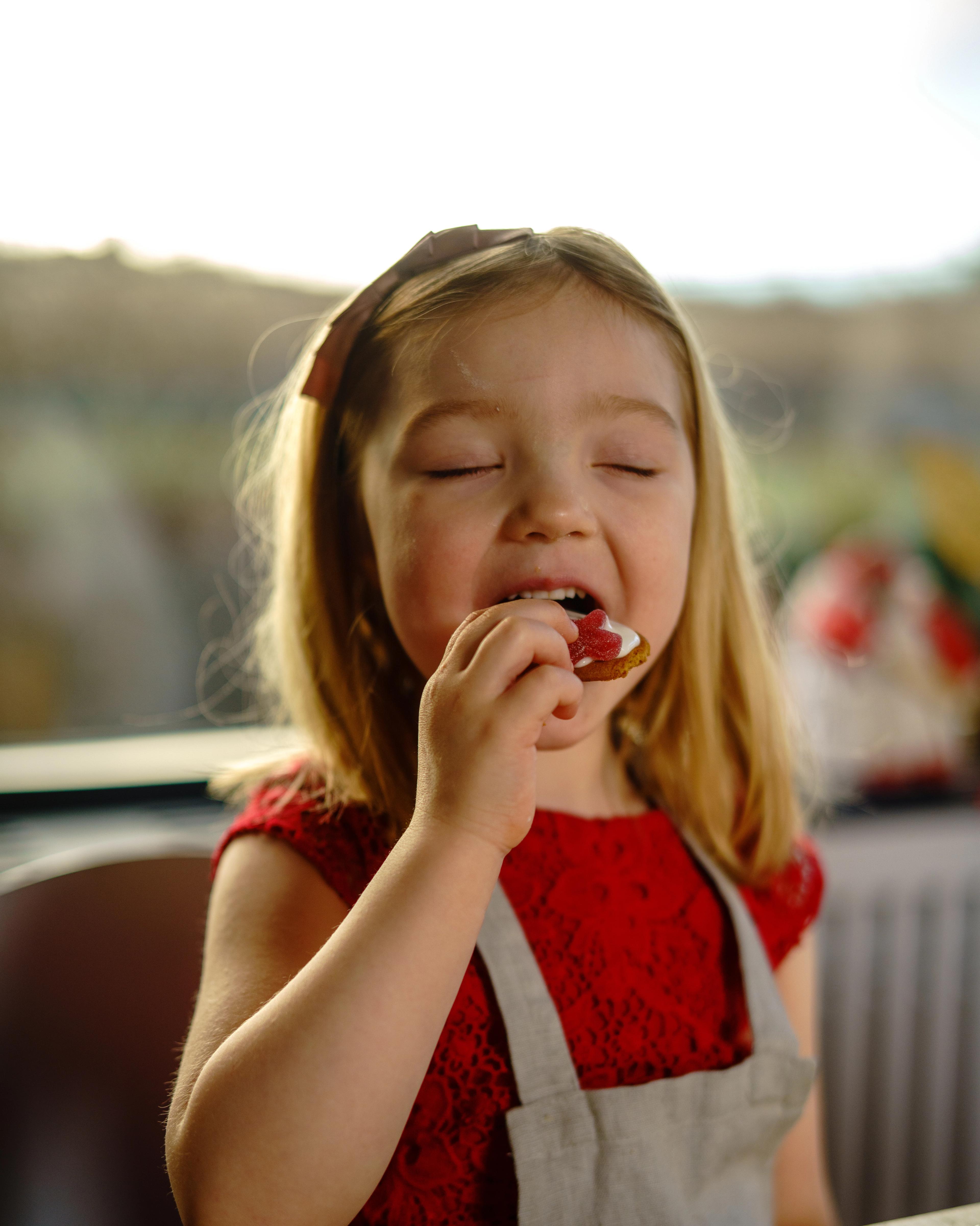 Andrea (5) takes a bite of a christmas cookie