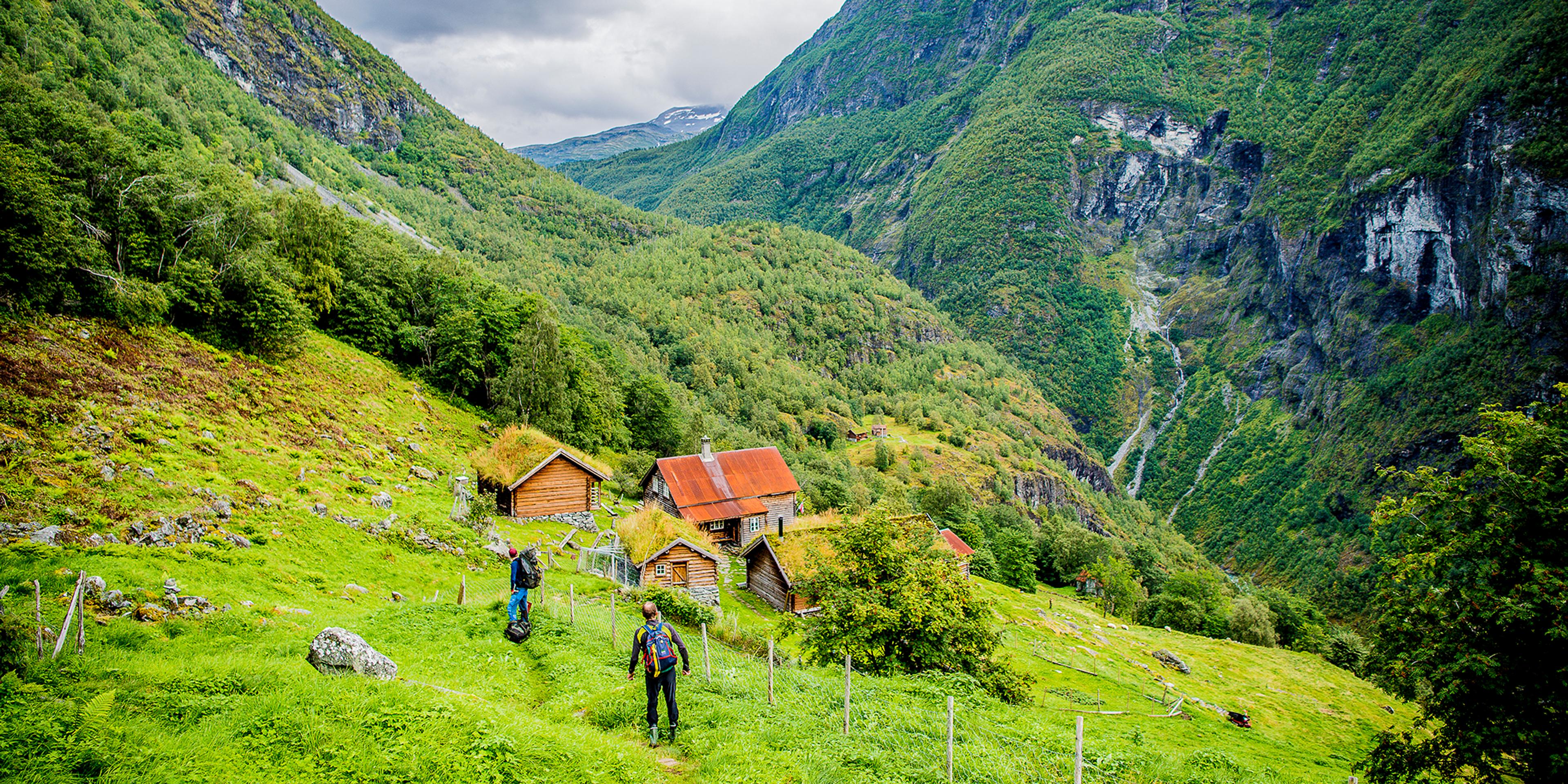 Dos personas caminan hacia las instalaciones de la granja de montaña Avdalen Gard, en el valle de Utladalen, la Noruega de los fiordos.