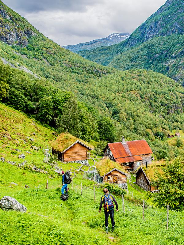 Twee mensen wandelen naar de bergboerderij Avdalen Gard in de Utladalen-vallei, Fjord-Noorwegen