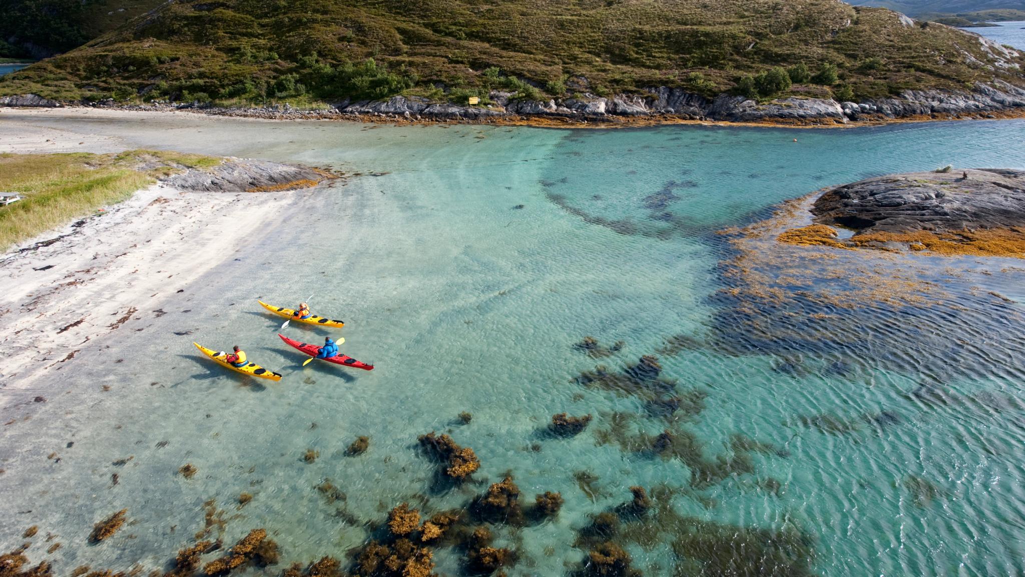 Tre kajakpaddlare vid Rødøy i Helgeland, norra Norge