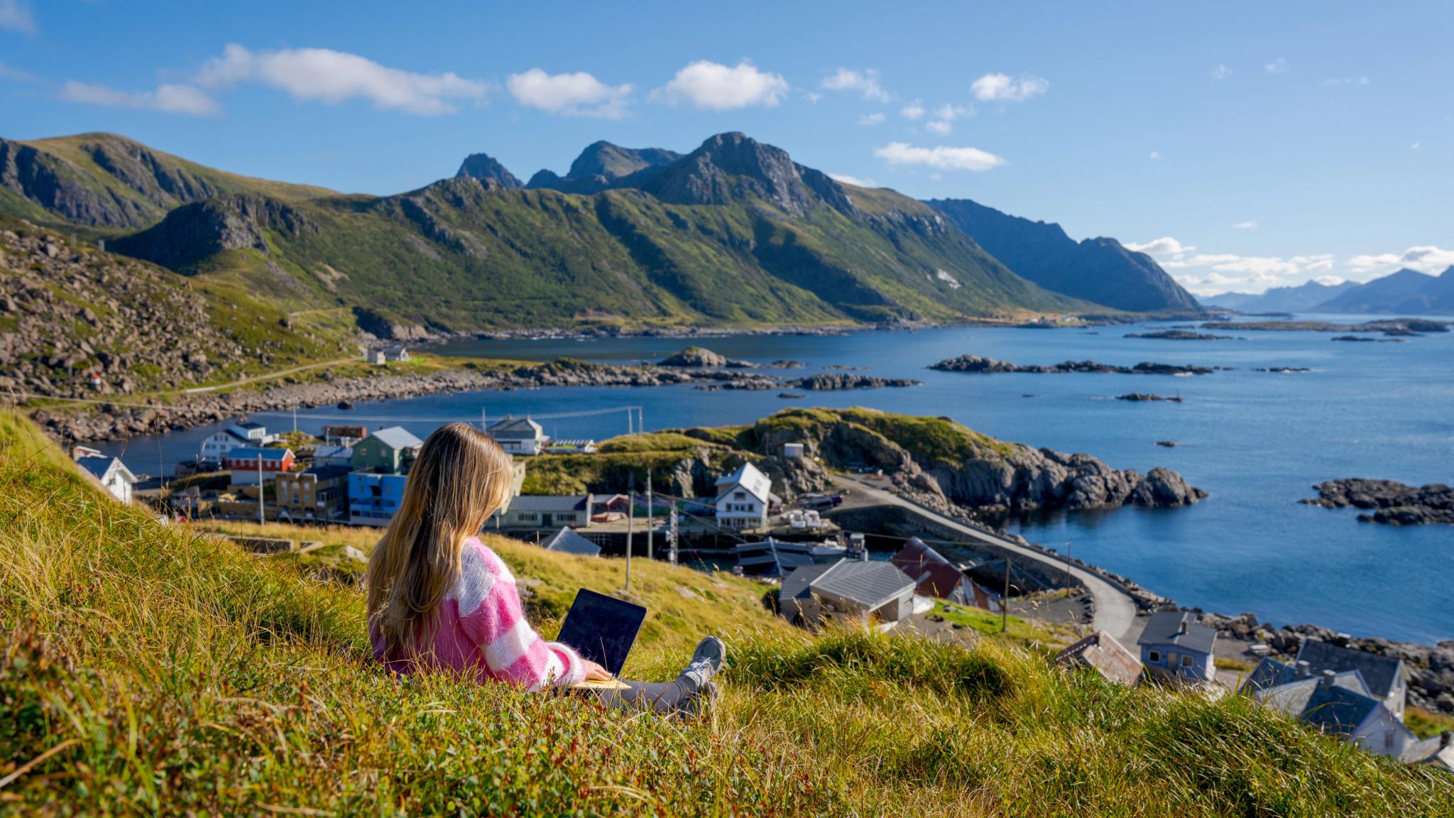 En kvinne jobber ute av kontoret fra Nyksund, i vakkert landskap