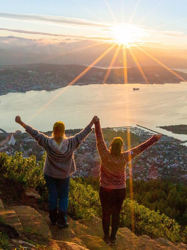 Two women are hiking up the Sherpa staircase to Mount Storsteinen in Tromsø, Northern Norway