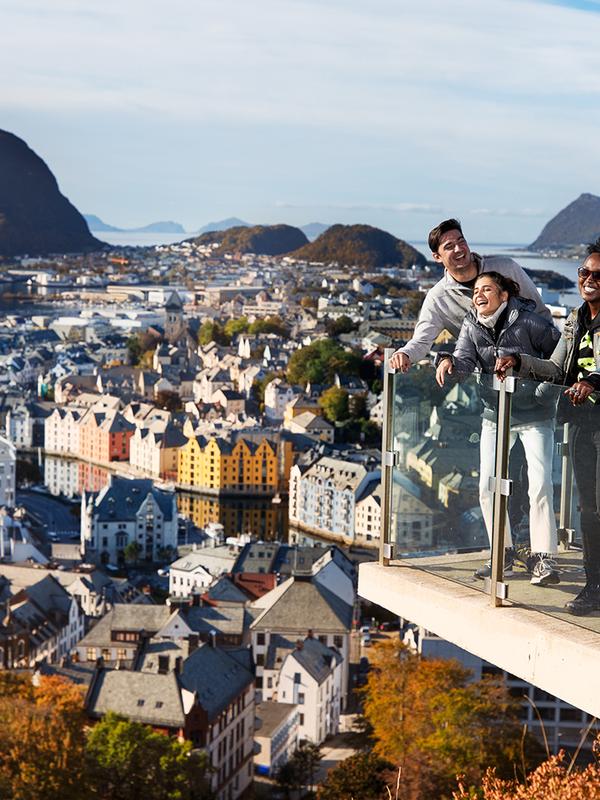 Drie mensen die op een uitkijkplatform staan op de berg Aksla in Ålesund, Fjord-Noorwegen