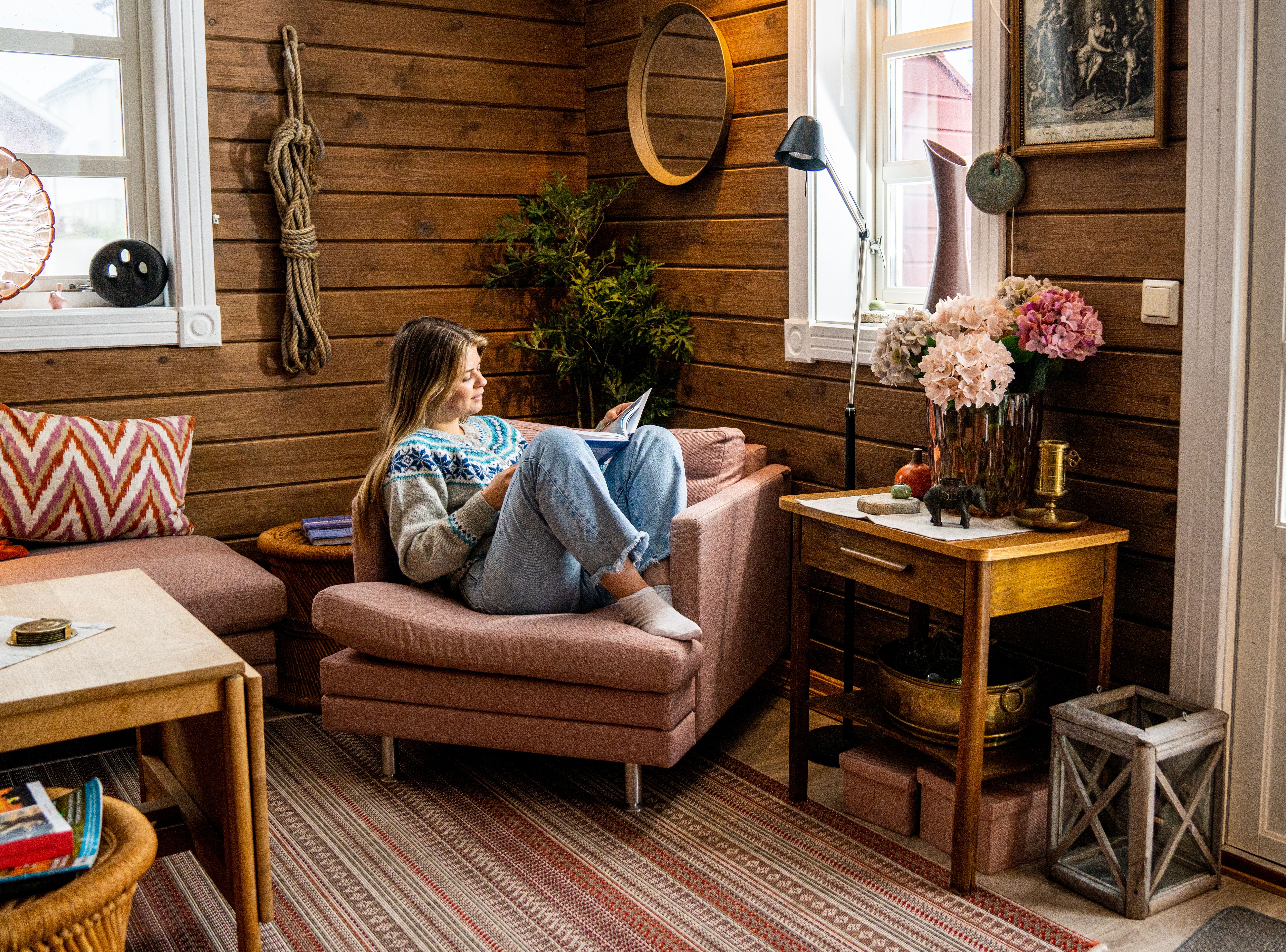 A woman reading a book in a fisherman's cabin by the sea, at Veiholmen outside Smøla in the Northwest