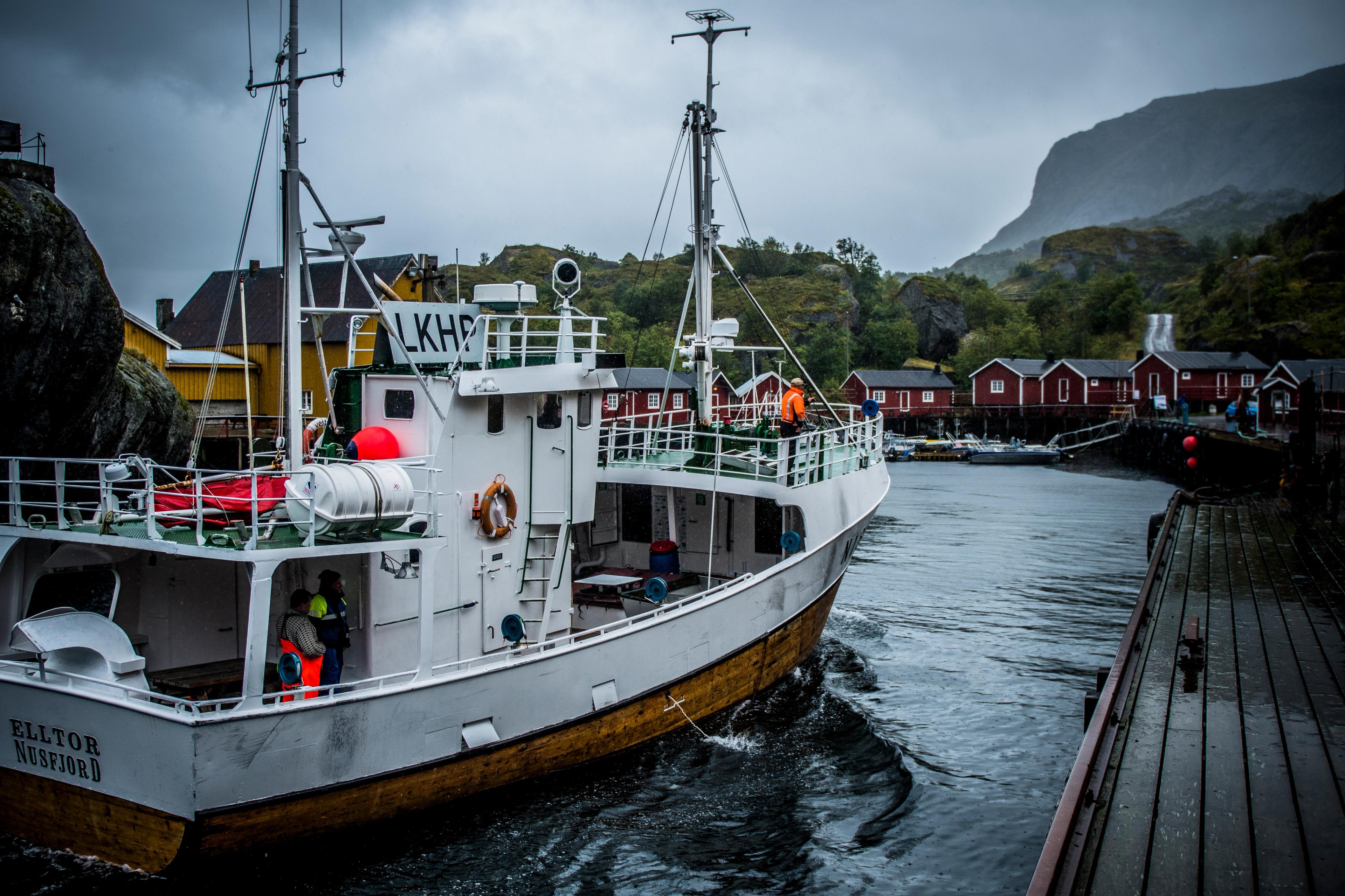 A fishing boat is coming in to Nusfjord fishing village in Lofoten, Northern Norway