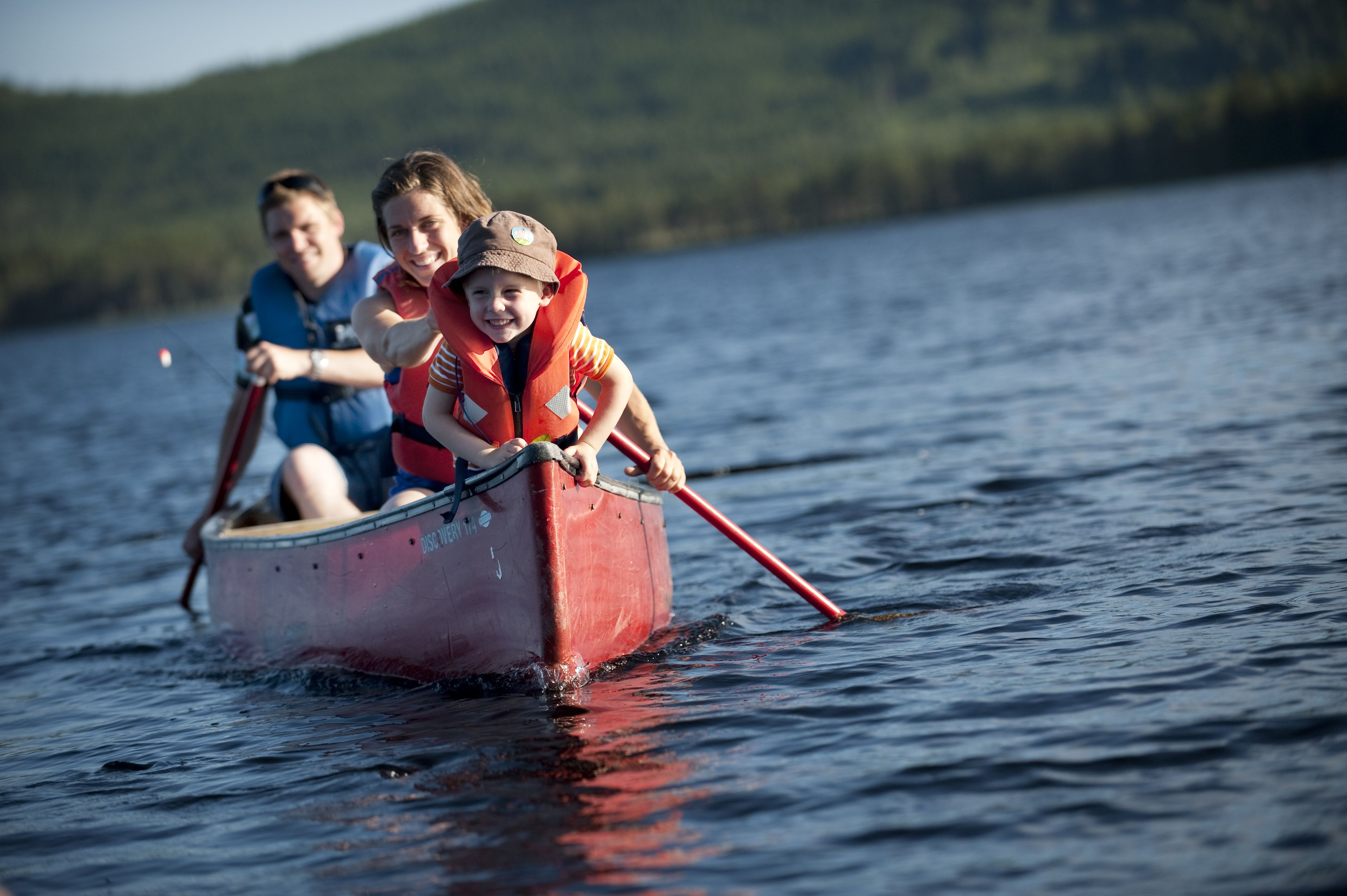 Family canoeing on the river in Trysil, Eastern Norway