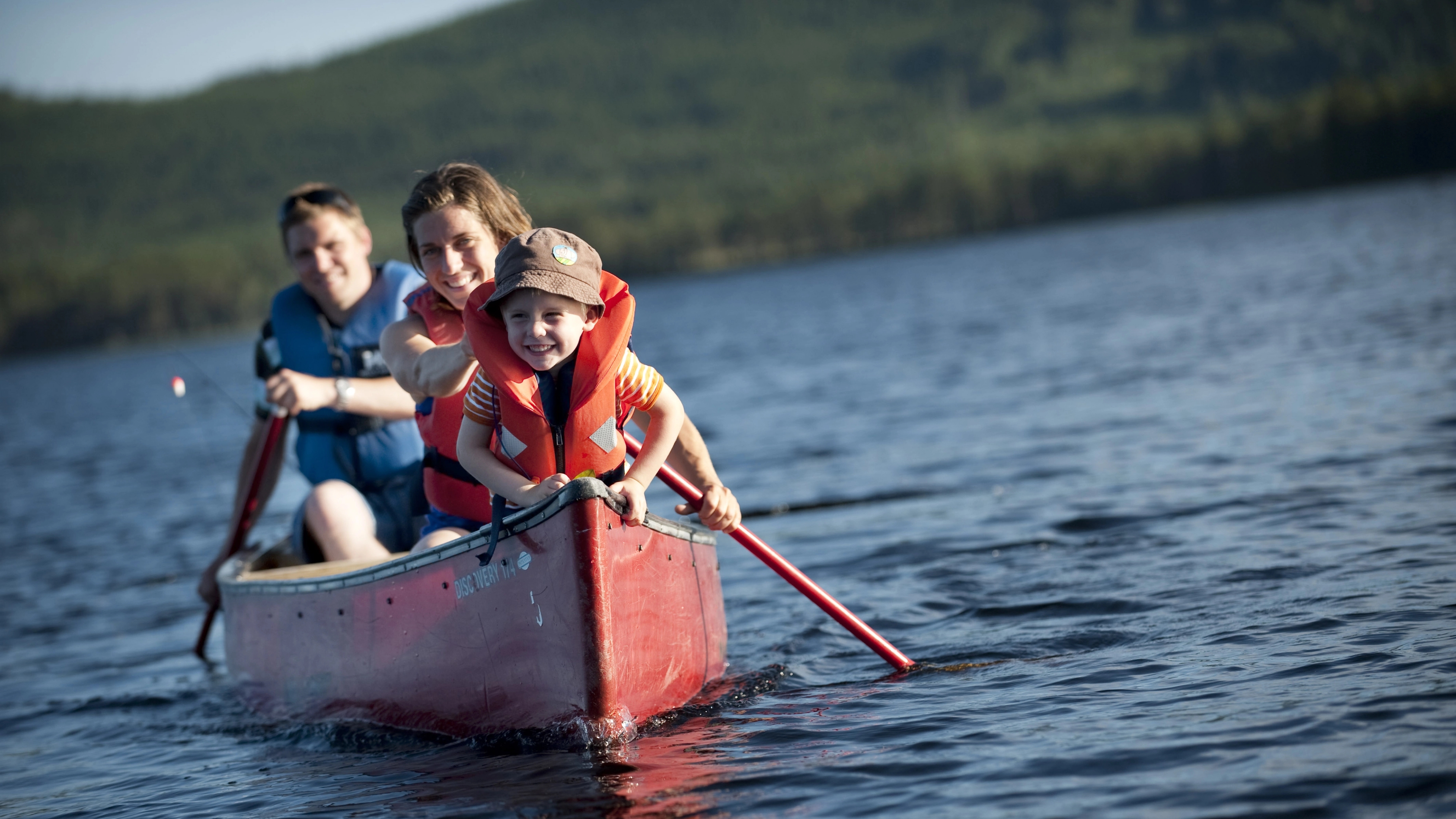 Family canoeing on the river in Trysil, Eastern Norway