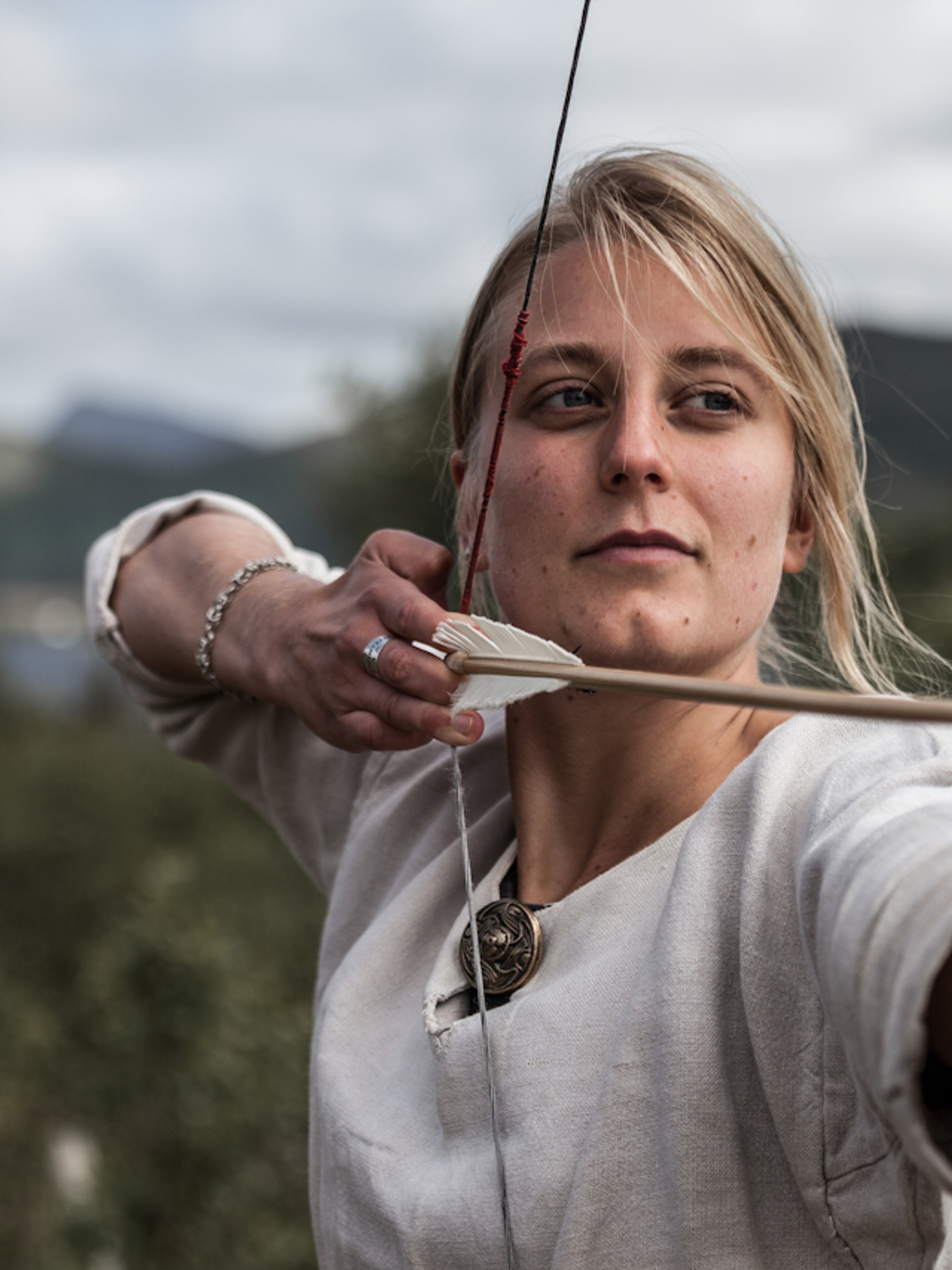 Woman shooting with a bow and arrow at the Lofotr Viking Museum