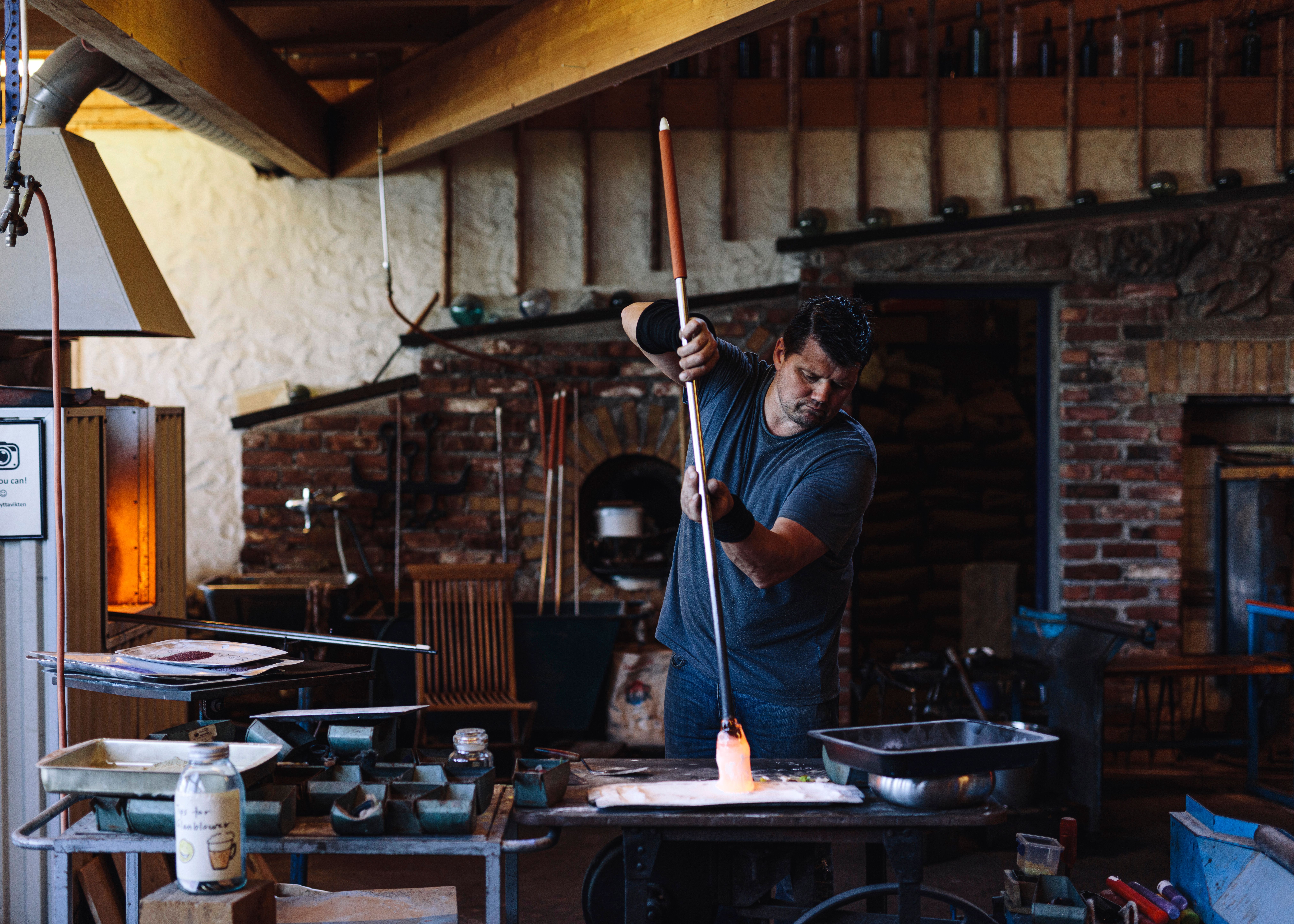 A craftsman performing the art of glassblowing at Vikten in Lofoten