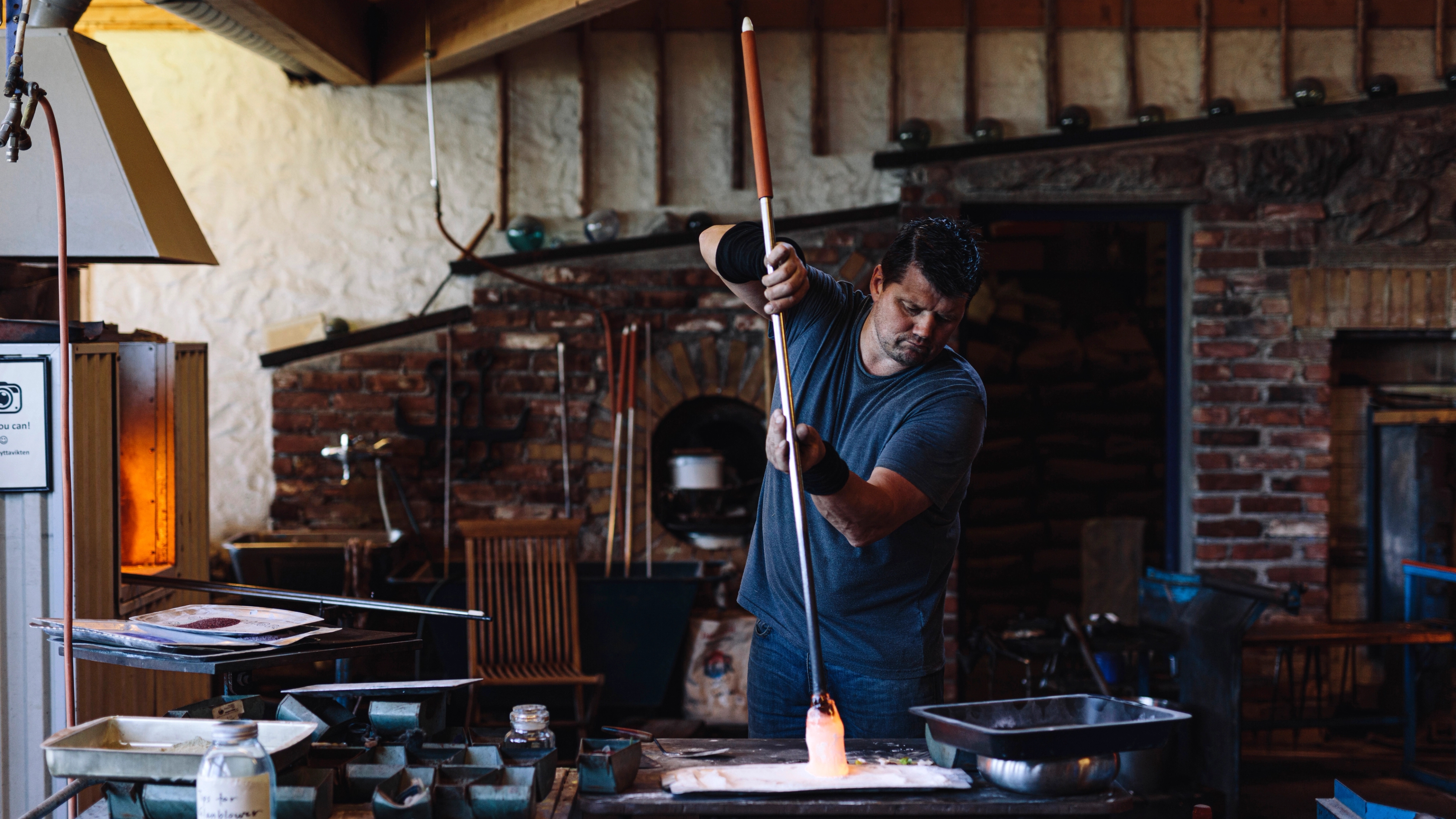 A craftsman performing the art of glassblowing at Vikten in Lofoten