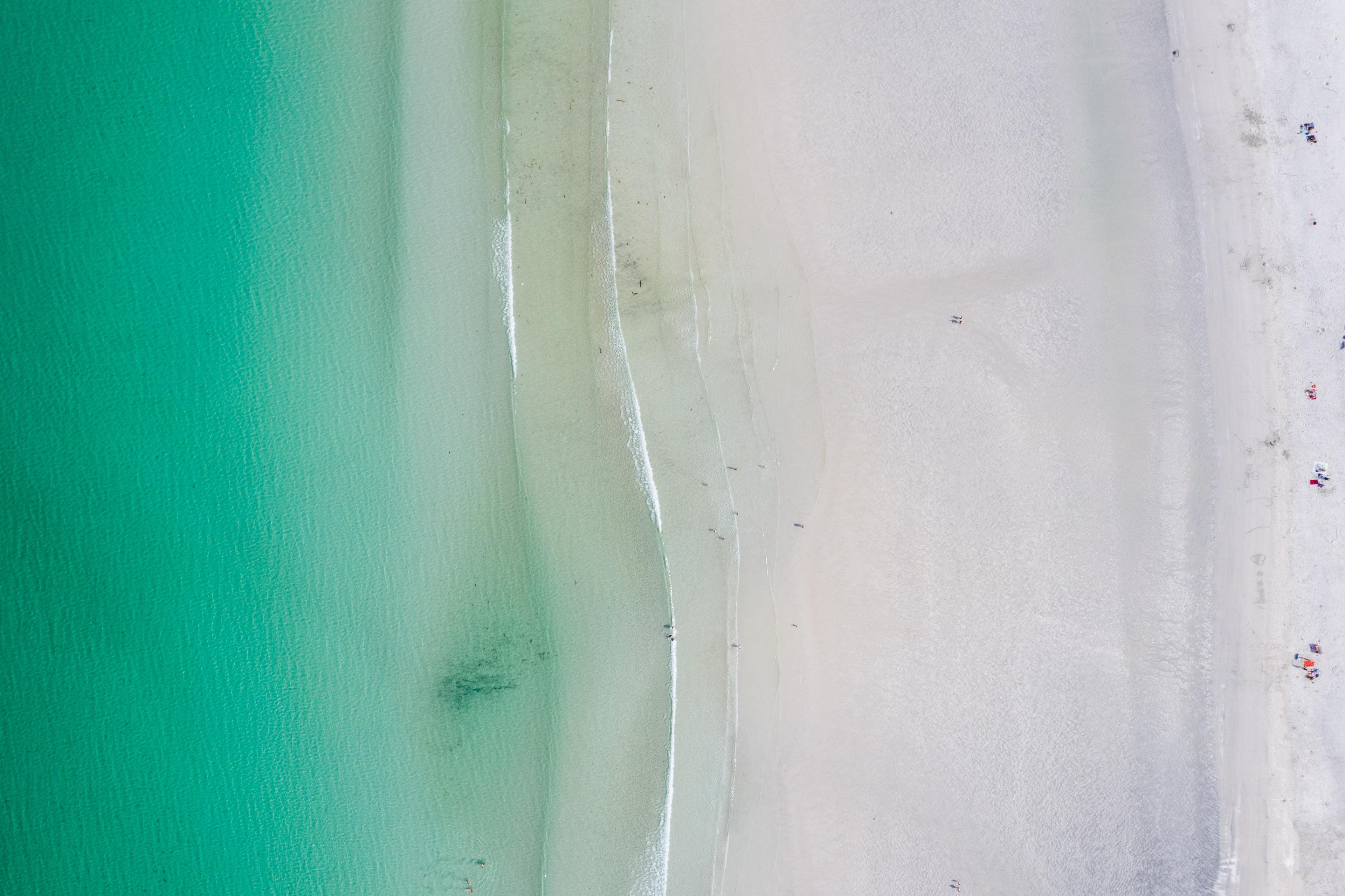 Overview of a sandy beach with clear blue water