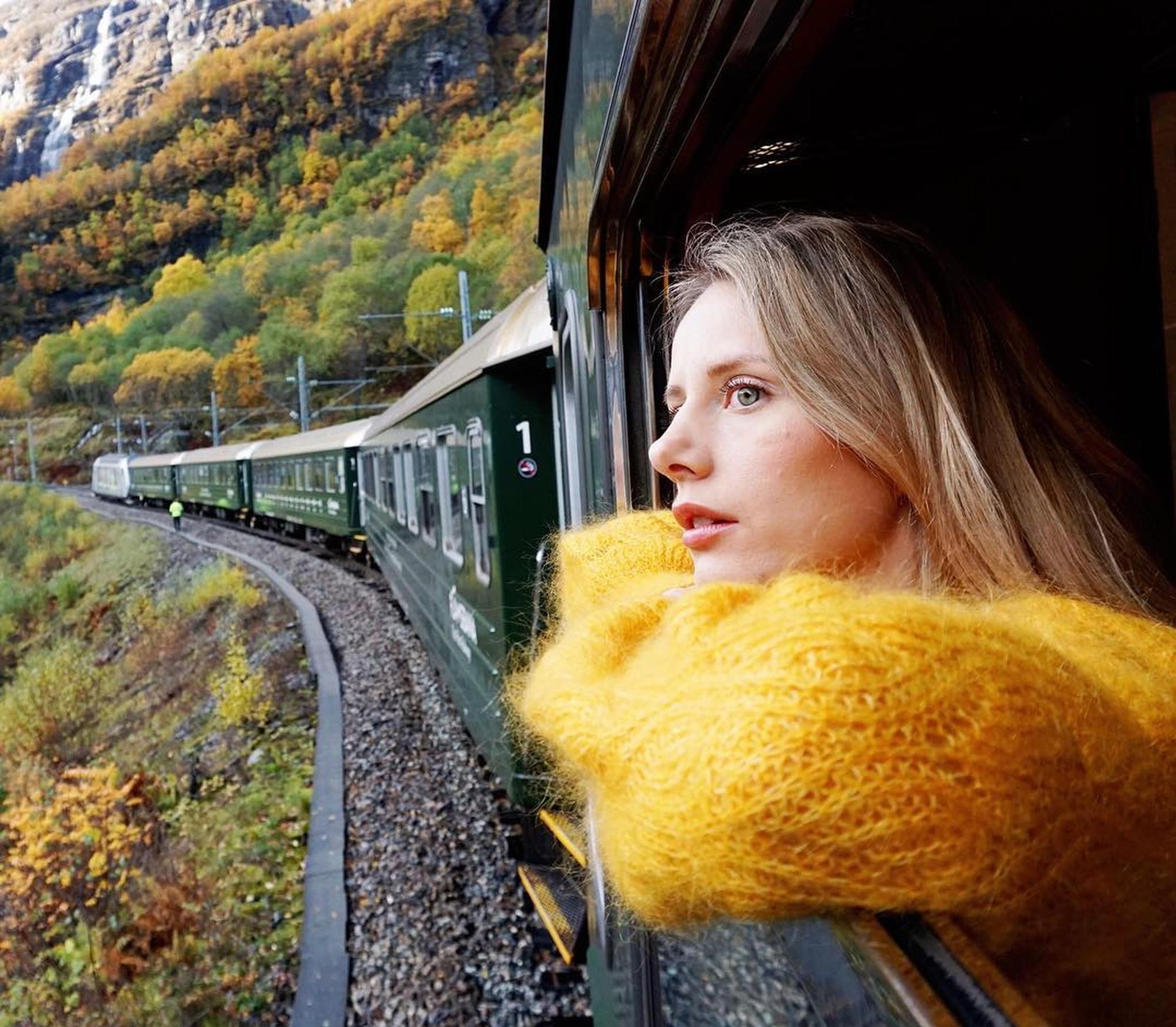 Girl in a yellow sweater looking out the train window