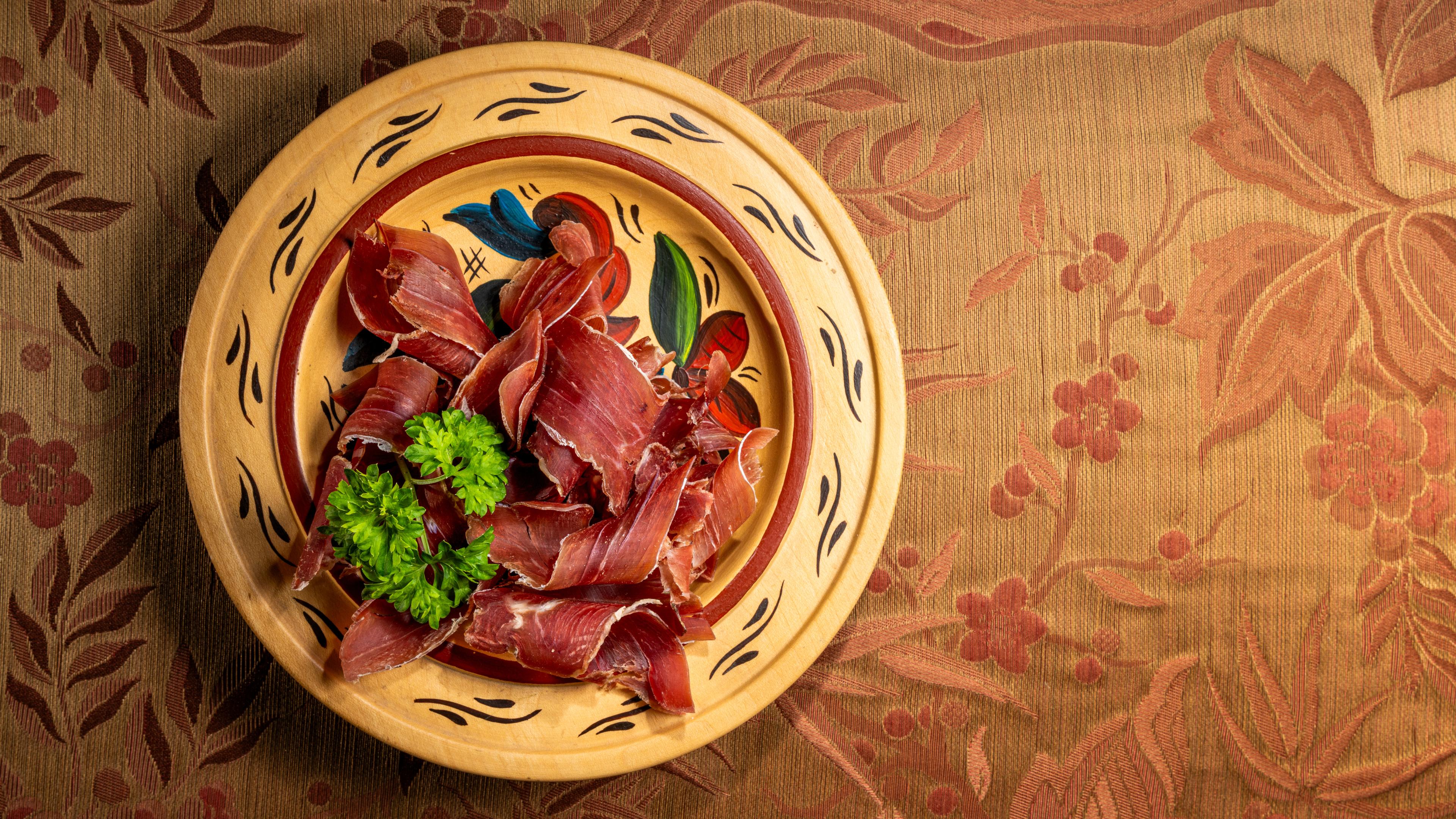 Slices of fenalår made of cured lamb meat on a plate