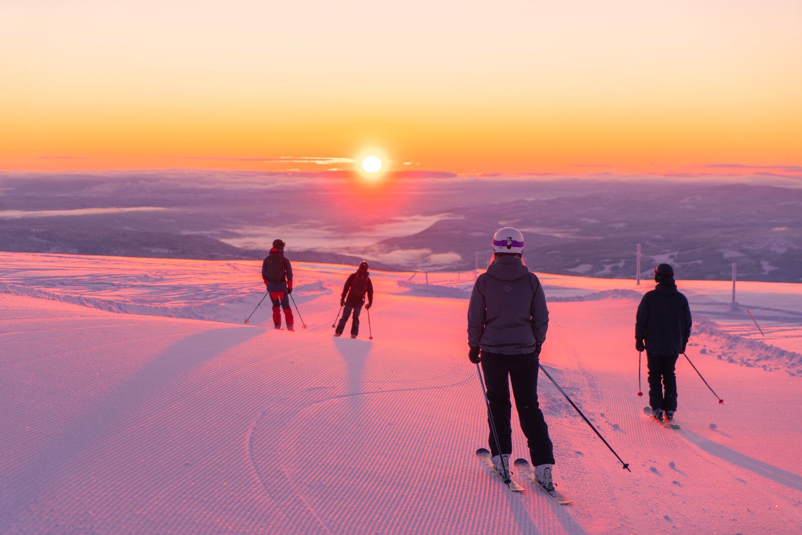 Four people skiing downhill in sunrise at Norefjell ski resort, Eastern Norway