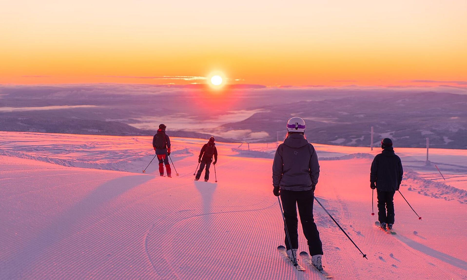 Four people skiing downhill in sunrise at Norefjell ski resort, Eastern Norway