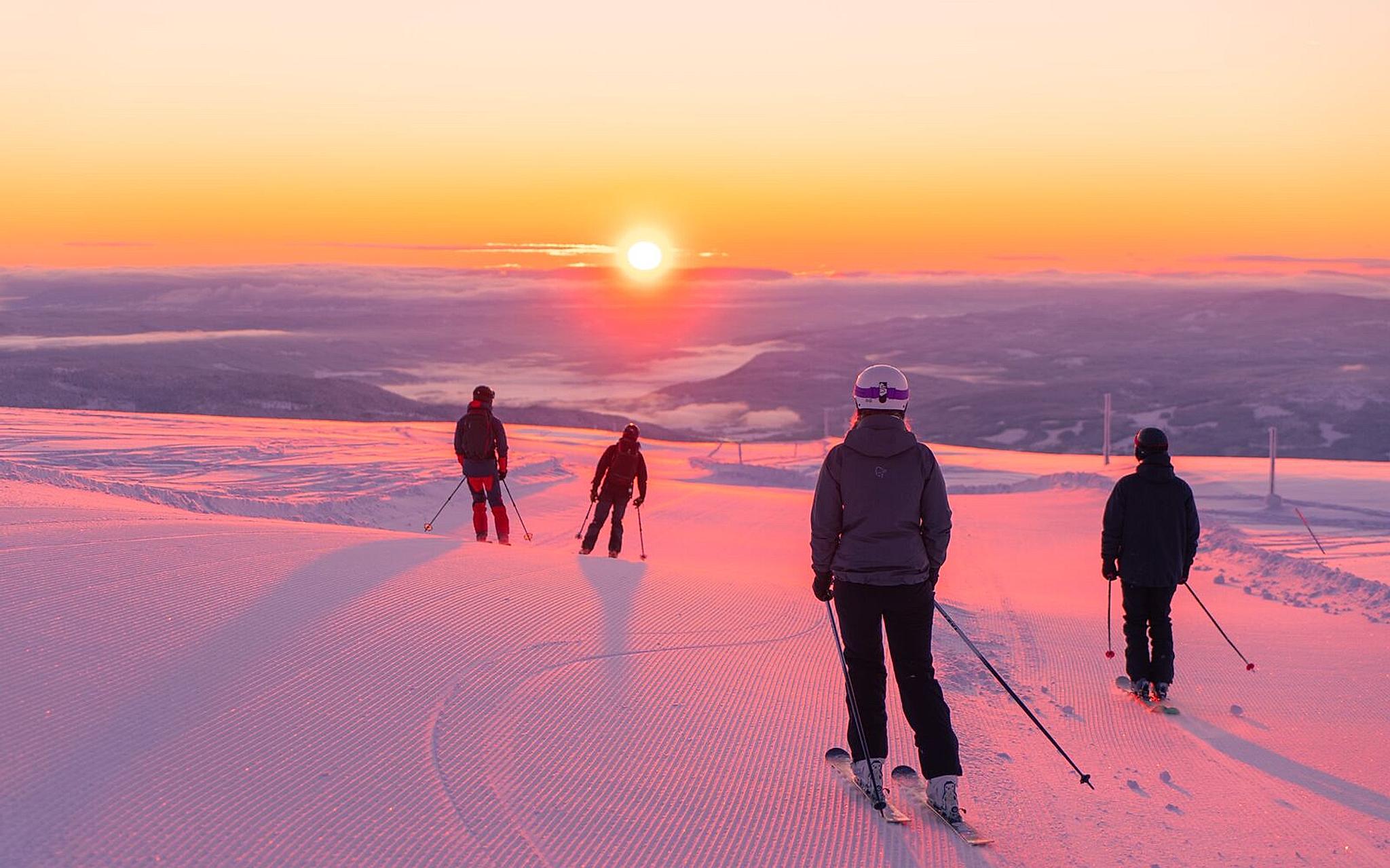 Four people skiing downhill in sunrise at Norefjell ski resort, Eastern Norway