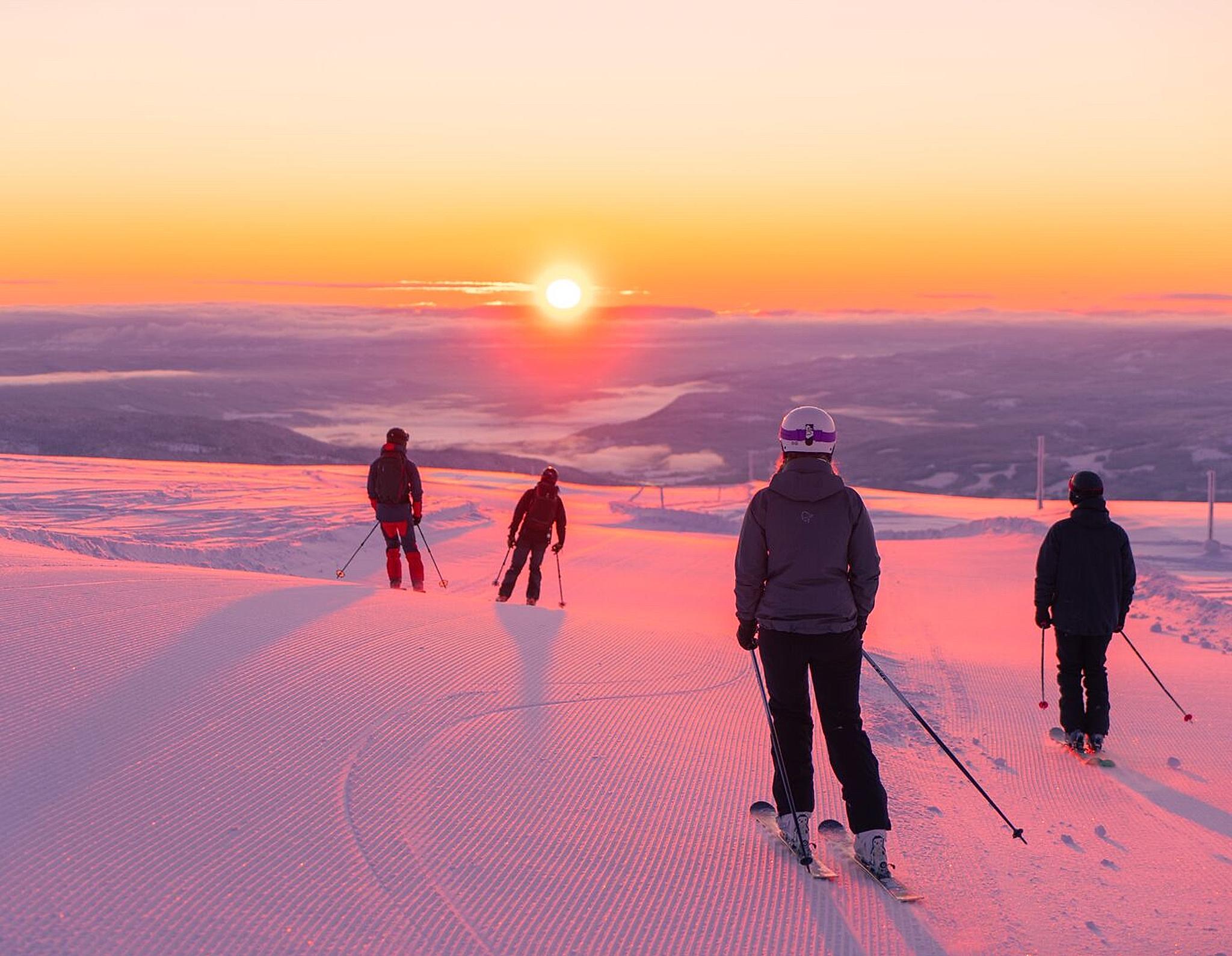 Four people skiing downhill in sunrise at Norefjell ski resort, Eastern Norway