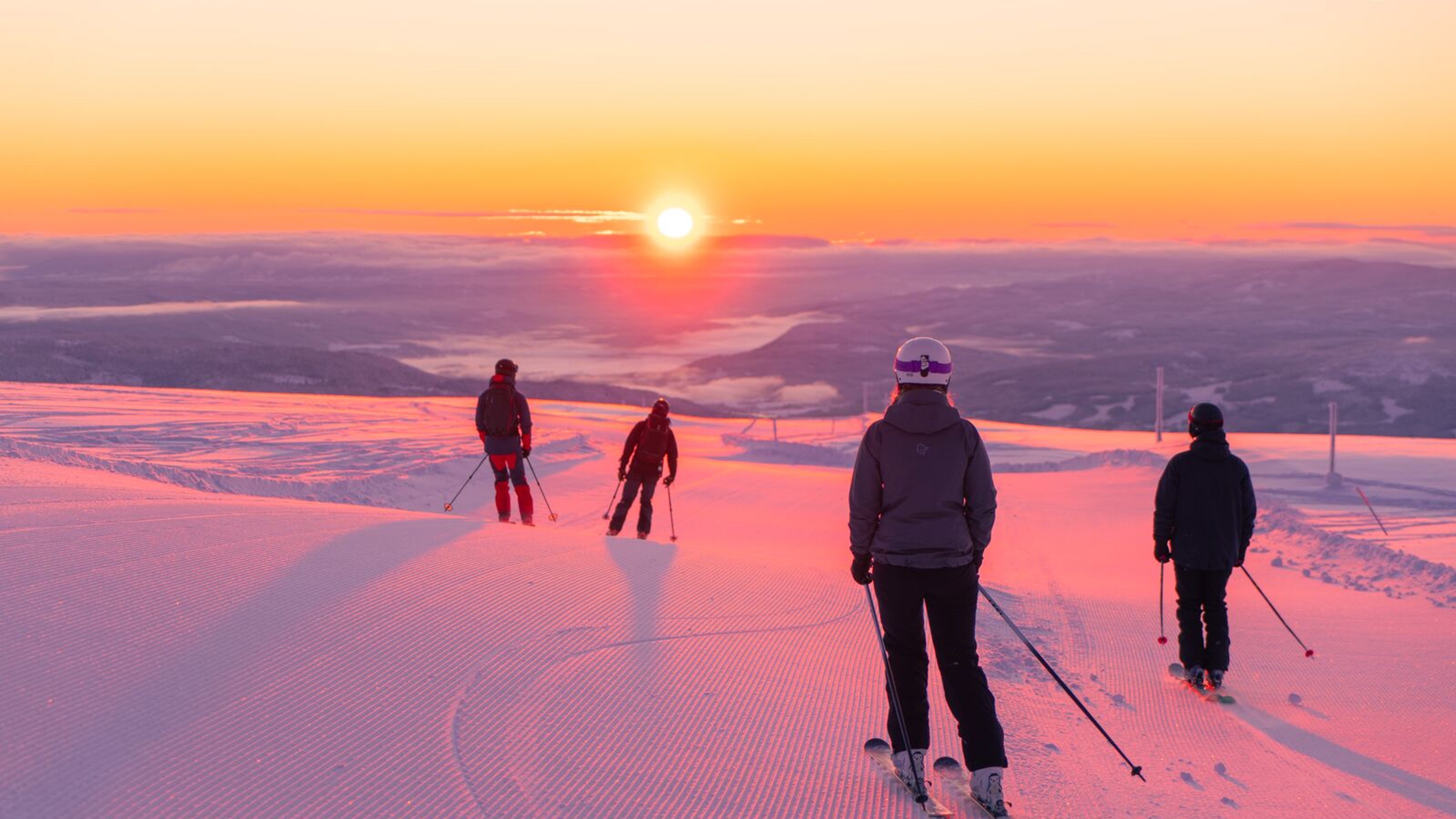 Four people skiing downhill in sunrise at Norefjell ski resort, Eastern Norway