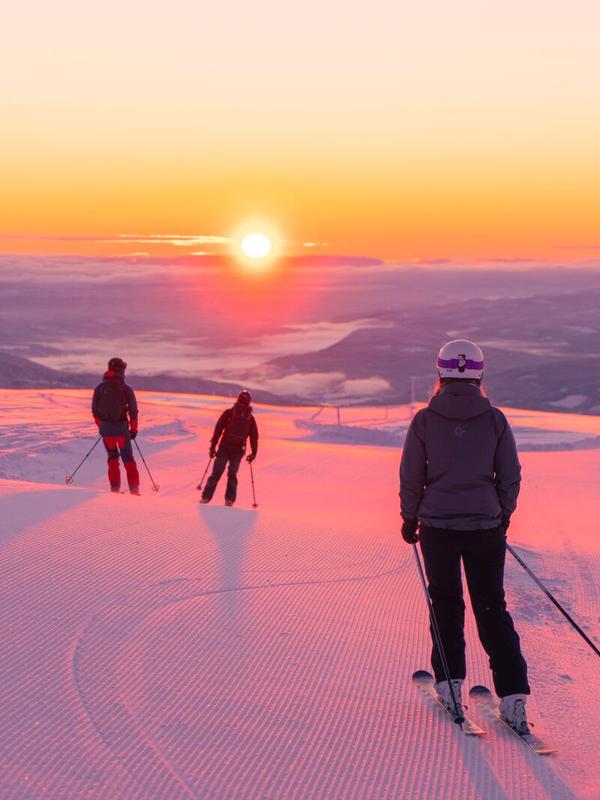 Four people skiing downhill in sunrise at Norefjell ski resort, Eastern Norway
