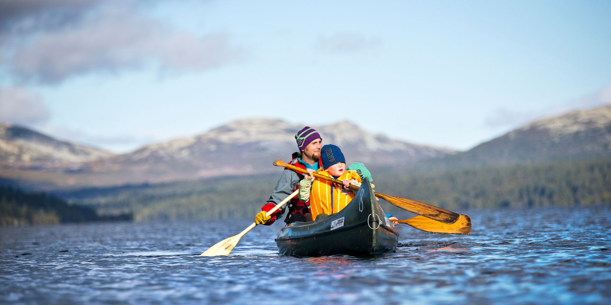 Padre e hijo montan en canoa durante una aventura en plena naturaleza para toda la familia en Femund Engerdal, Noruega.