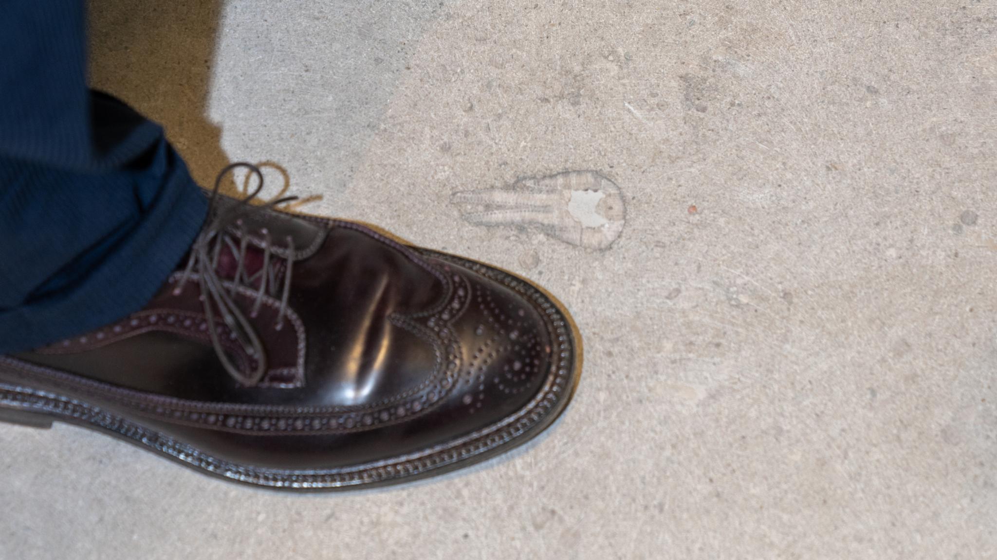 A foot by a fossil in the floor at the National Museum