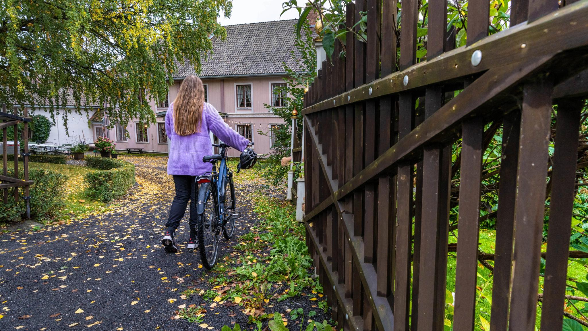 A woman arriving at Hovelsrud farm by bike, Eastern Norway.