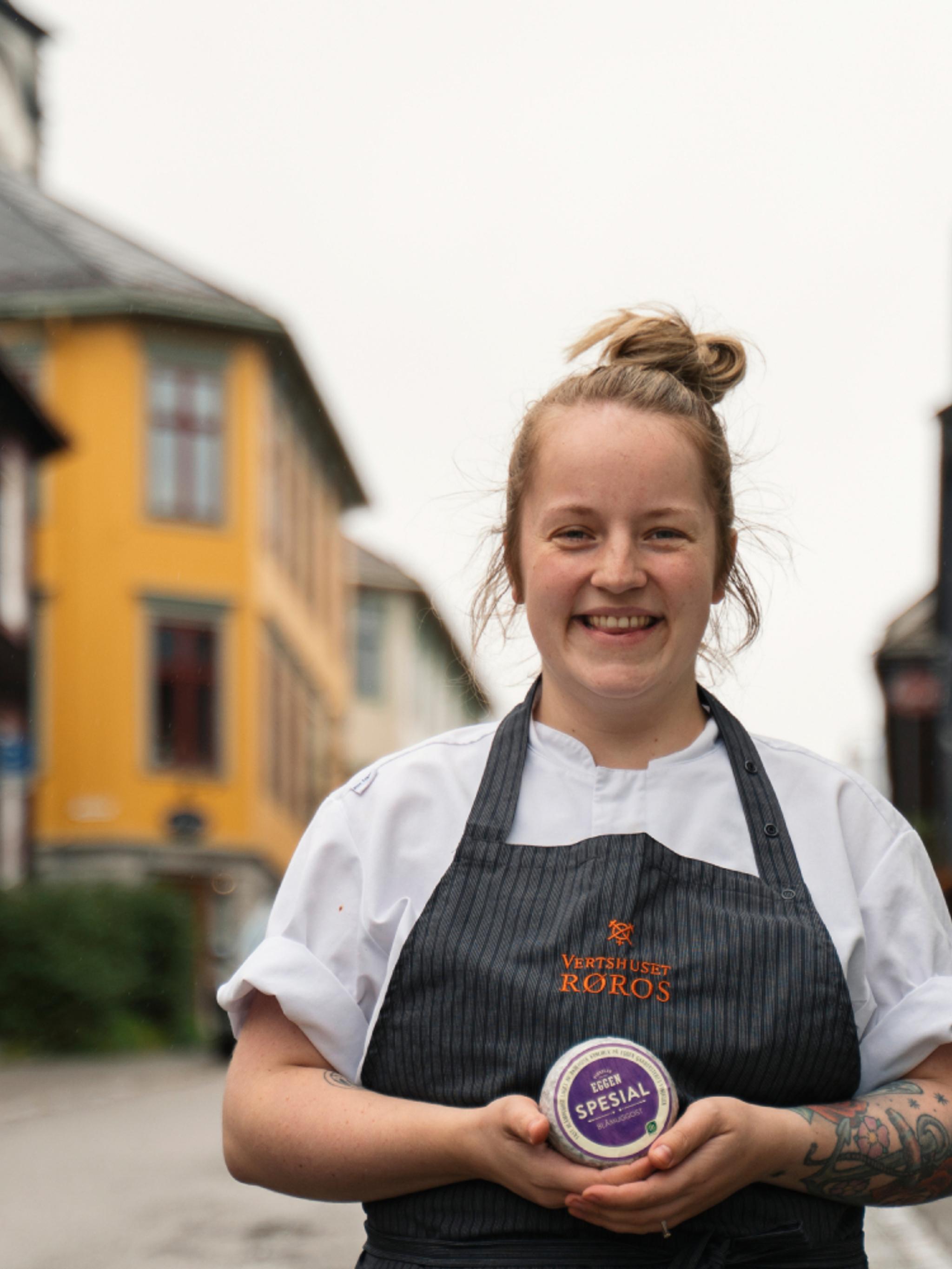 A woman posing with cheese from the cheese factory in Røros, Trøndelag