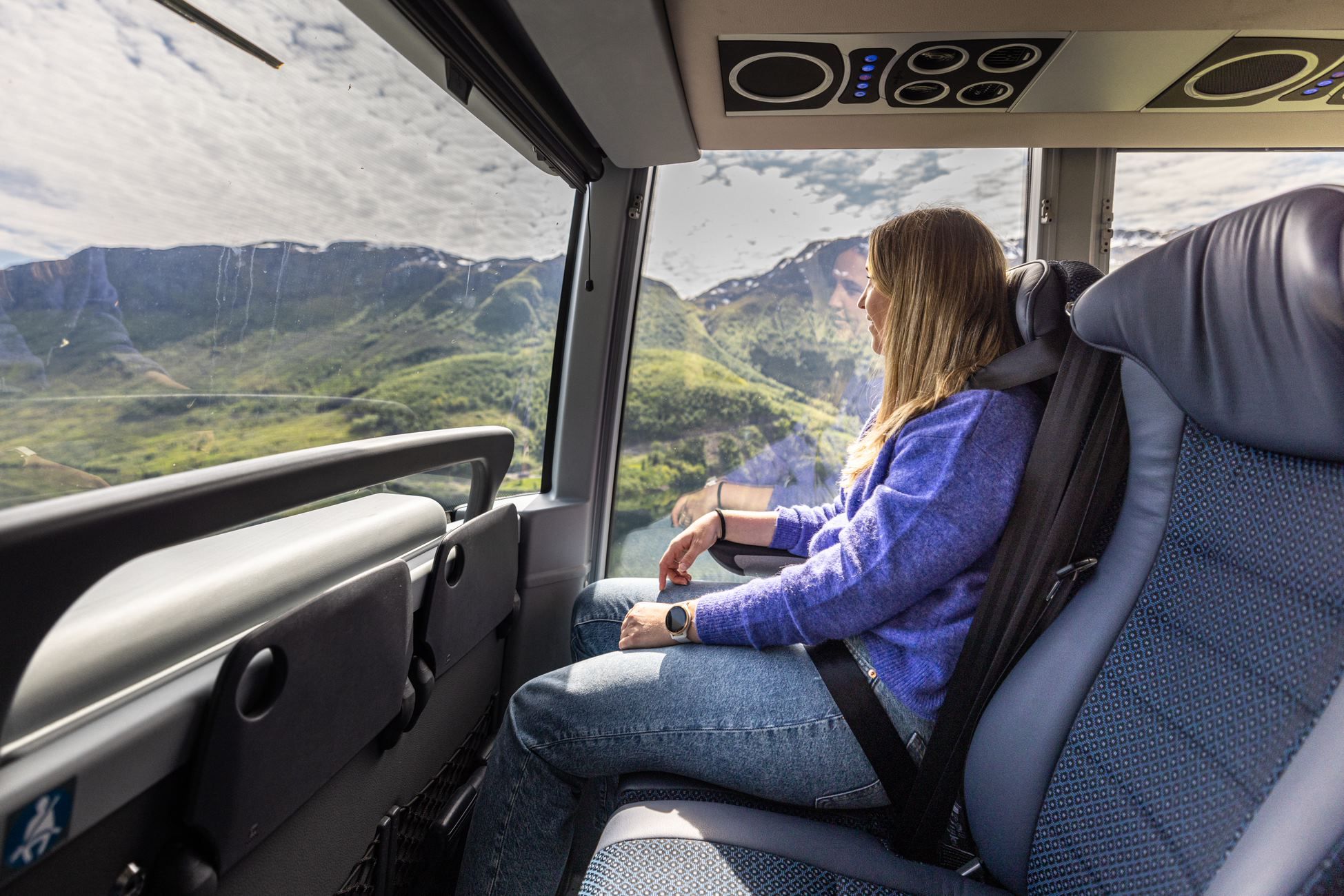 A woman enjoying the view from the bus.