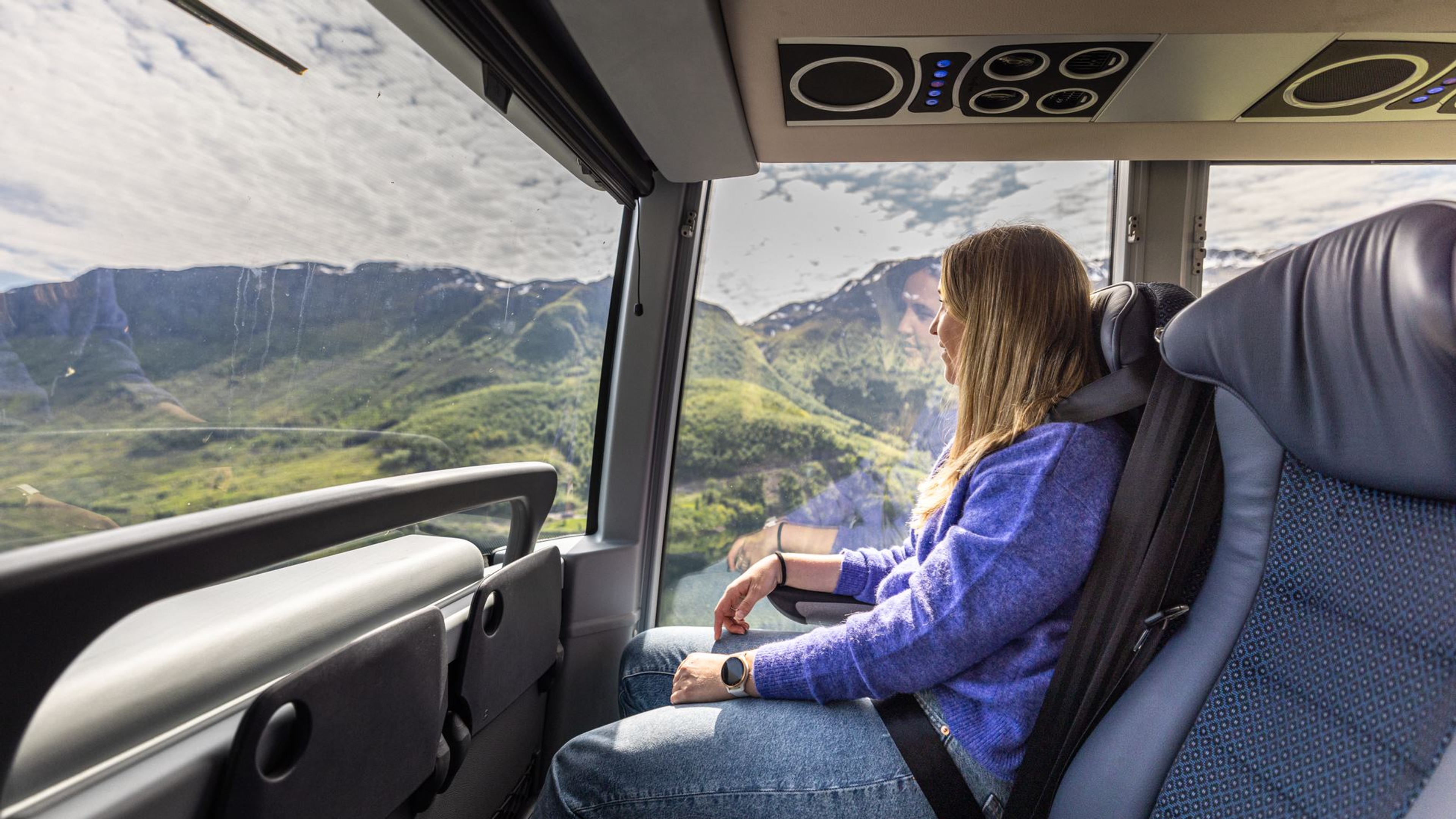 A woman enjoying the view from the bus.