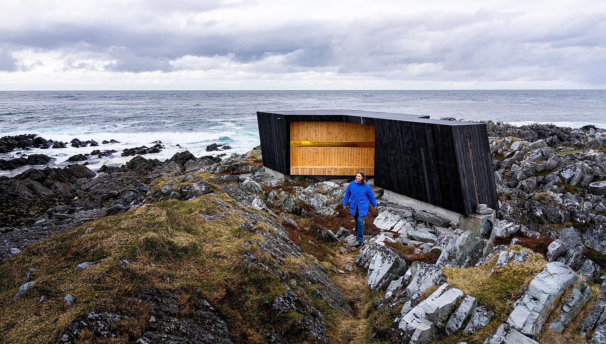 A woman outside of a birdwatching hide made by Biotope in Hamningberg, Varanger, Northern Norway