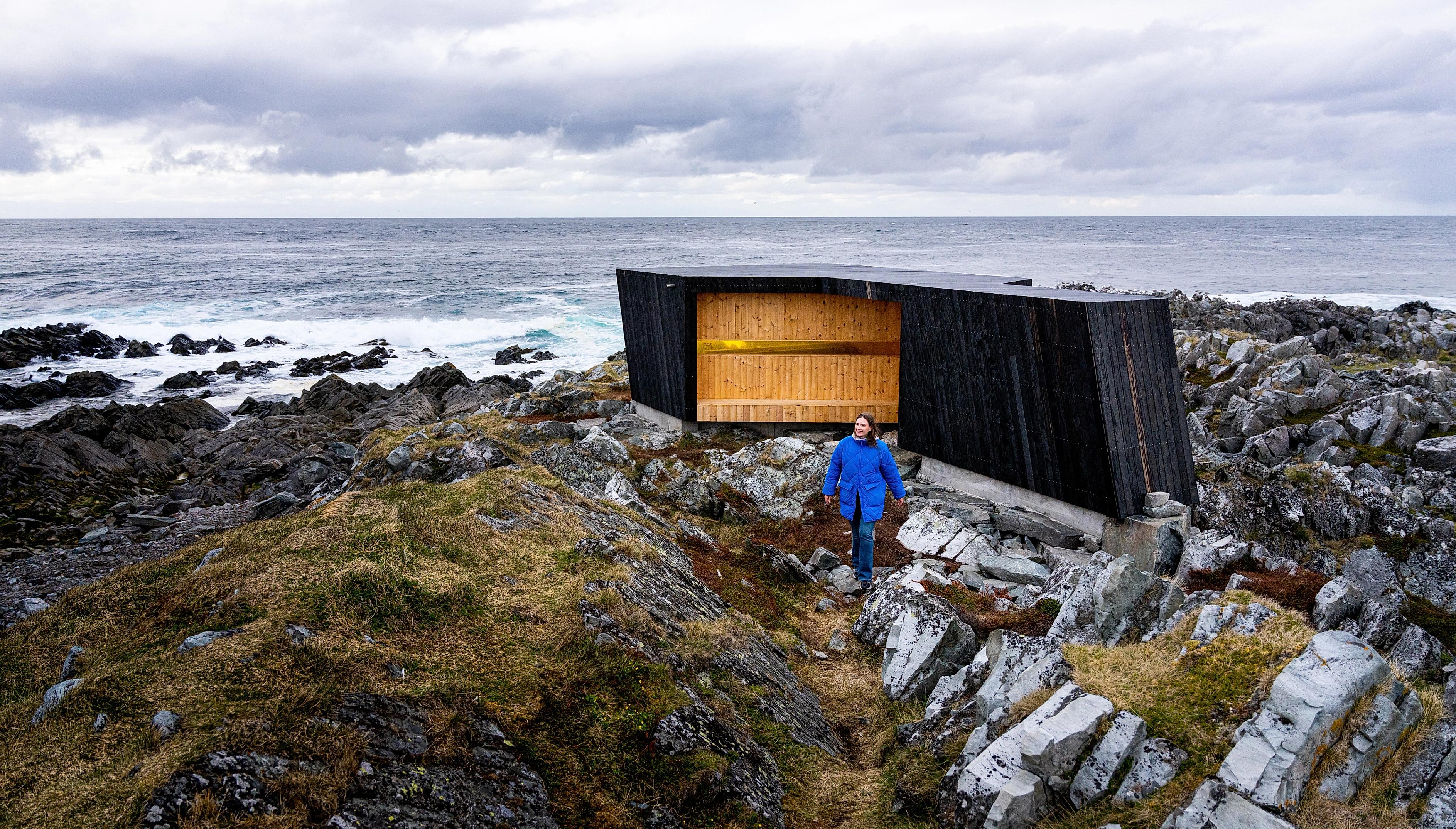 A woman outside of a birdwatching hide made by Biotope in Hamningberg, Varanger, Northern Norway