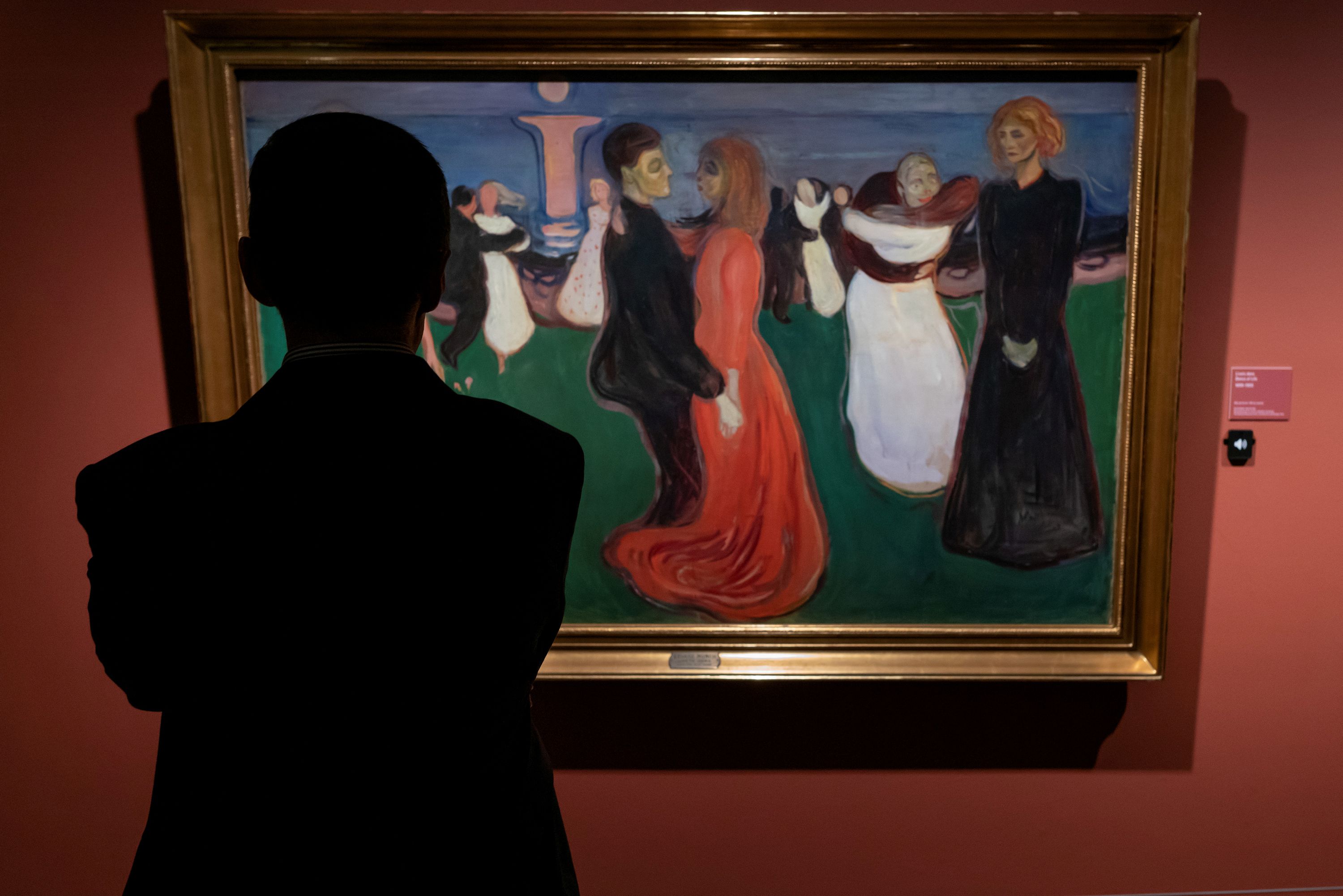 A man looking at a painting from Edvard Munch.