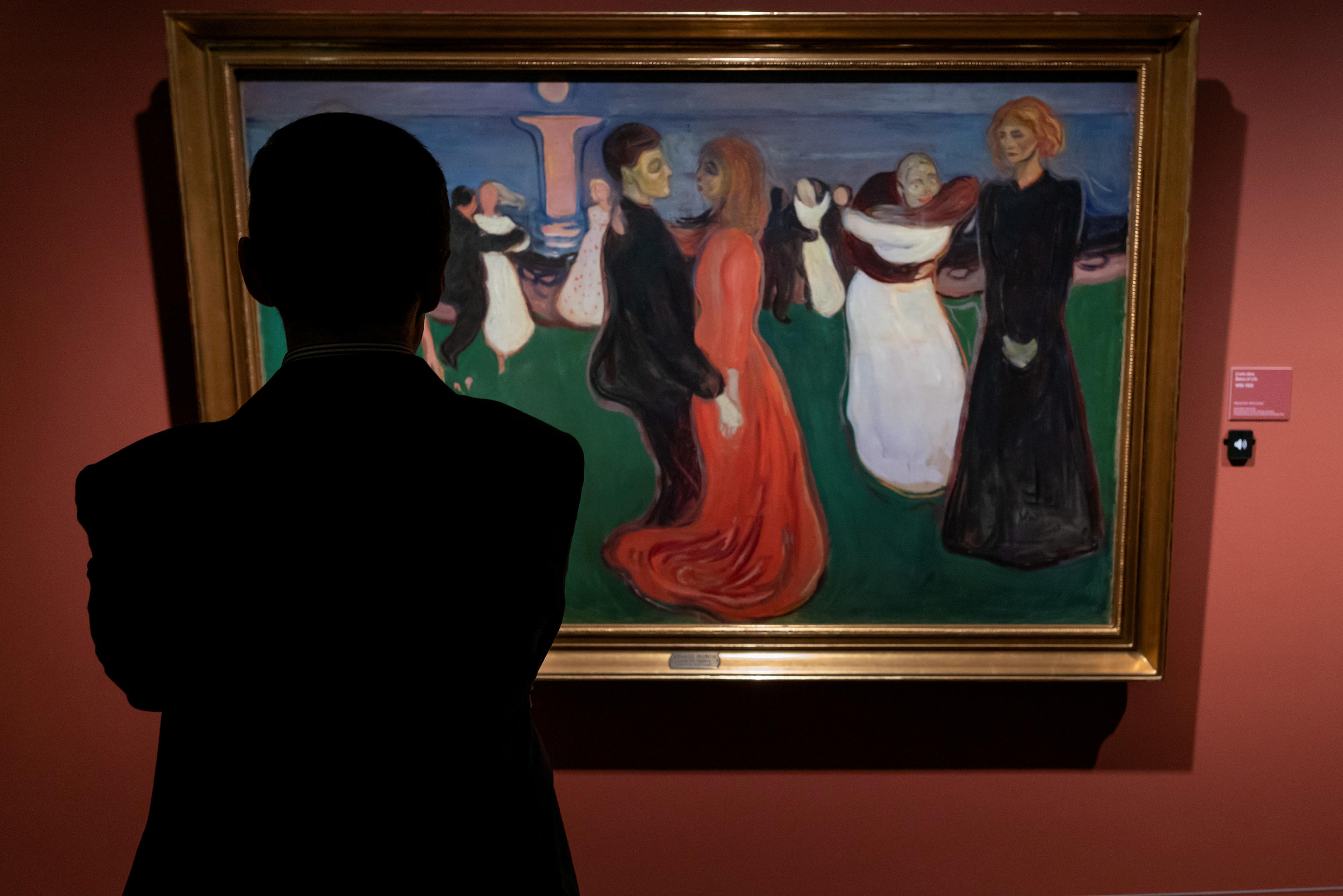 A man looking at a painting from Edvard Munch.