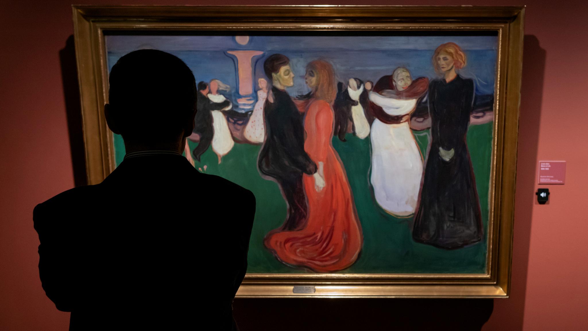A man looking at a painting from Edvard Munch.