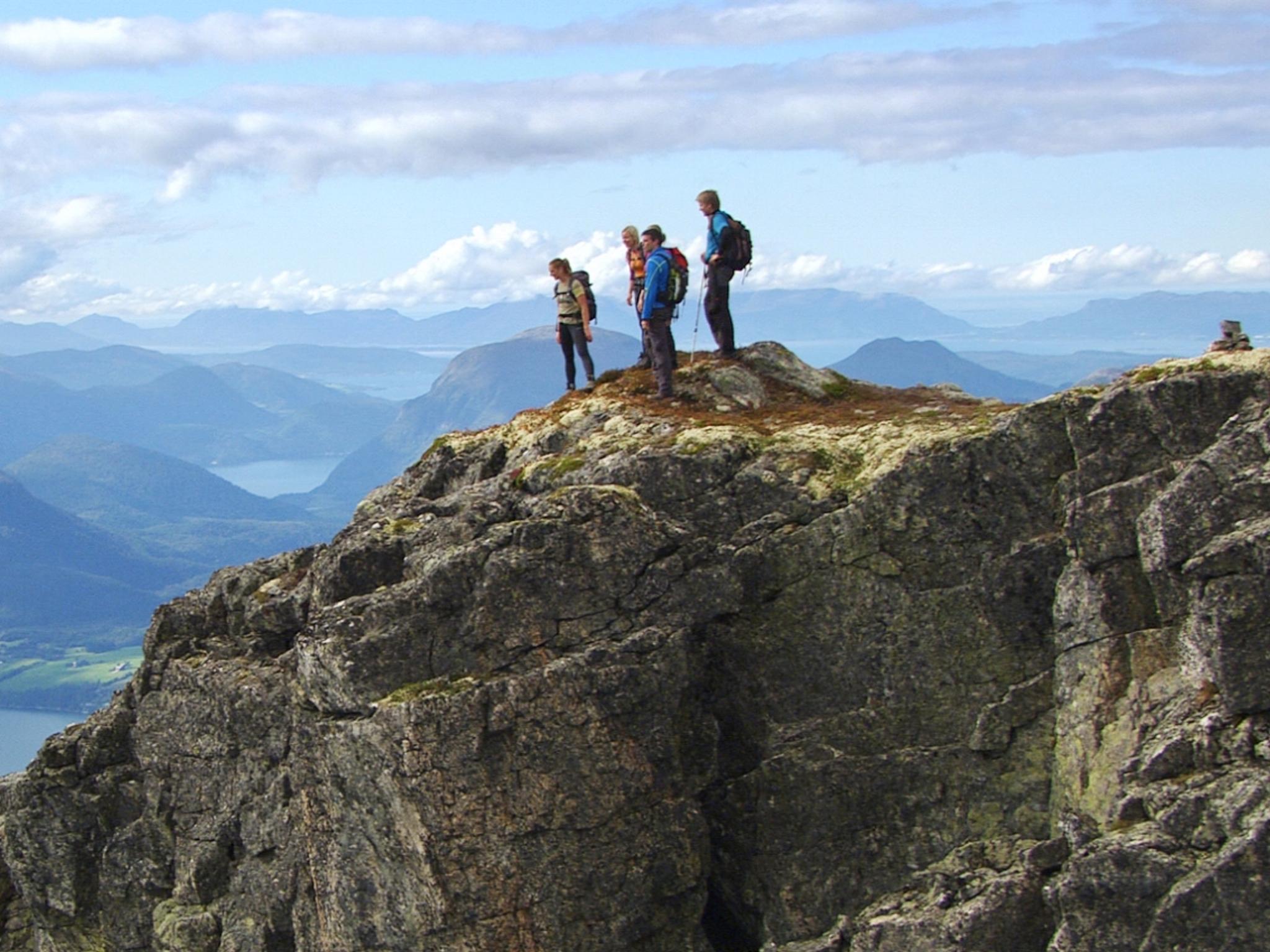 A group of people admire the view from Romsdalseggen in Fjord Norway
