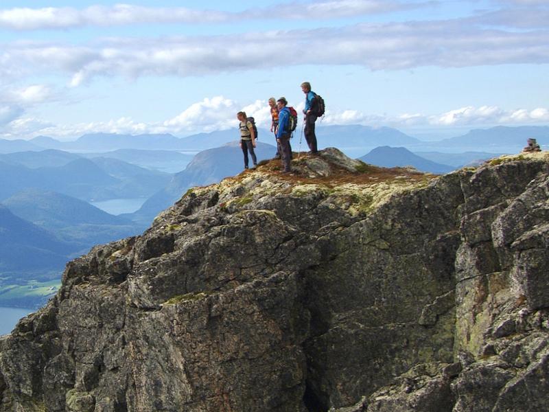 A group of people admire the view from Romsdalseggen in Fjord Norway