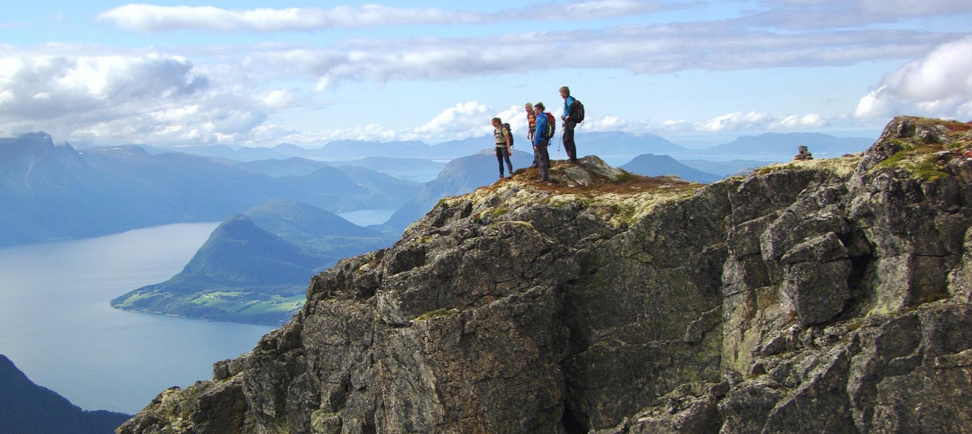 A group of people admire the view from Romsdalseggen in Fjord Norway