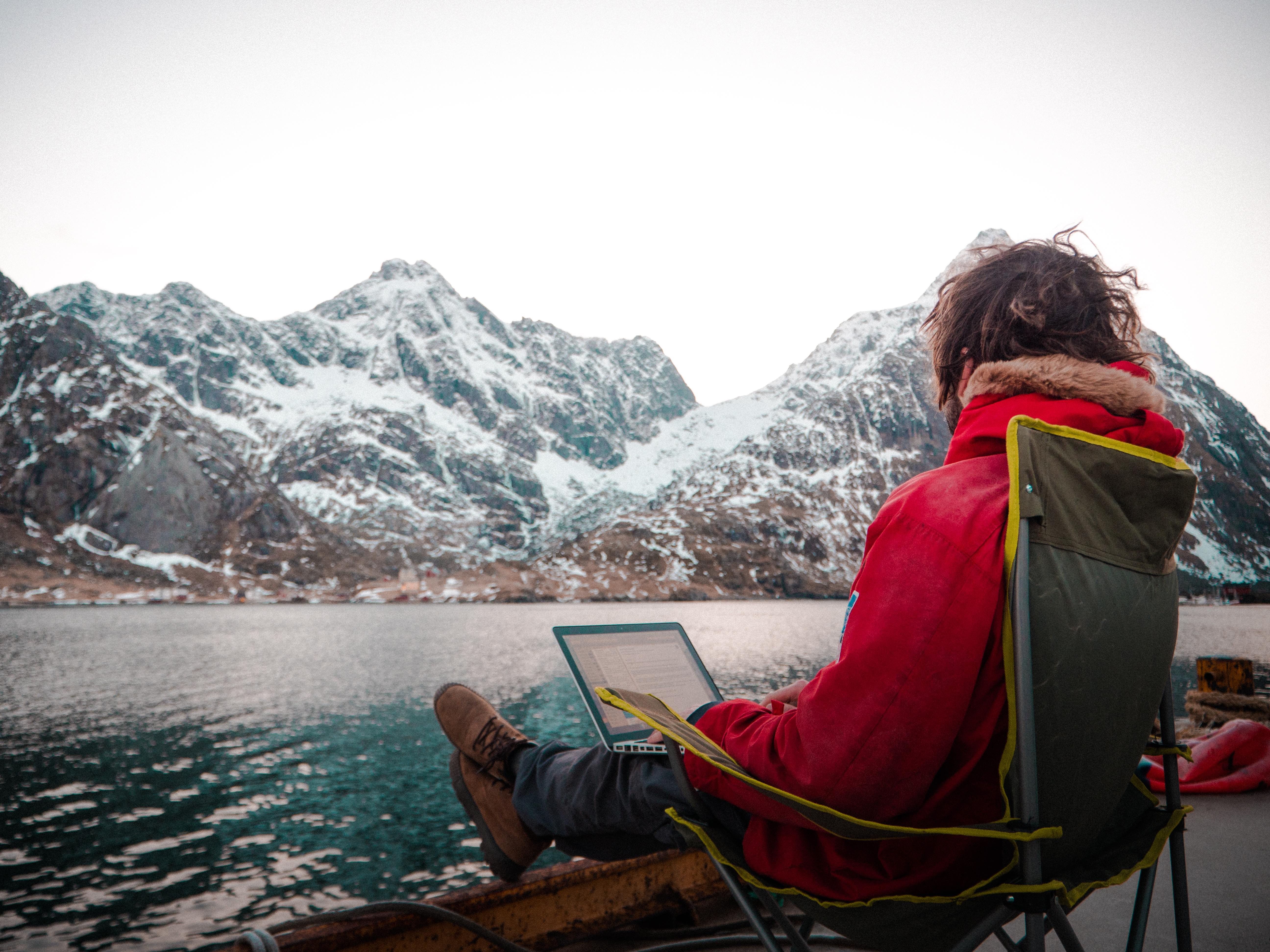 A man working outdoors by the sea at the Arctic Coworking Lodge in Lofoten, Northern Noway