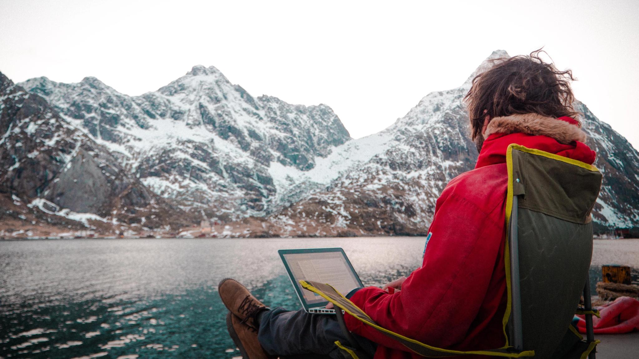 A man working outdoors by the sea at the Arctic Coworking Lodge in Lofoten, Northern Noway