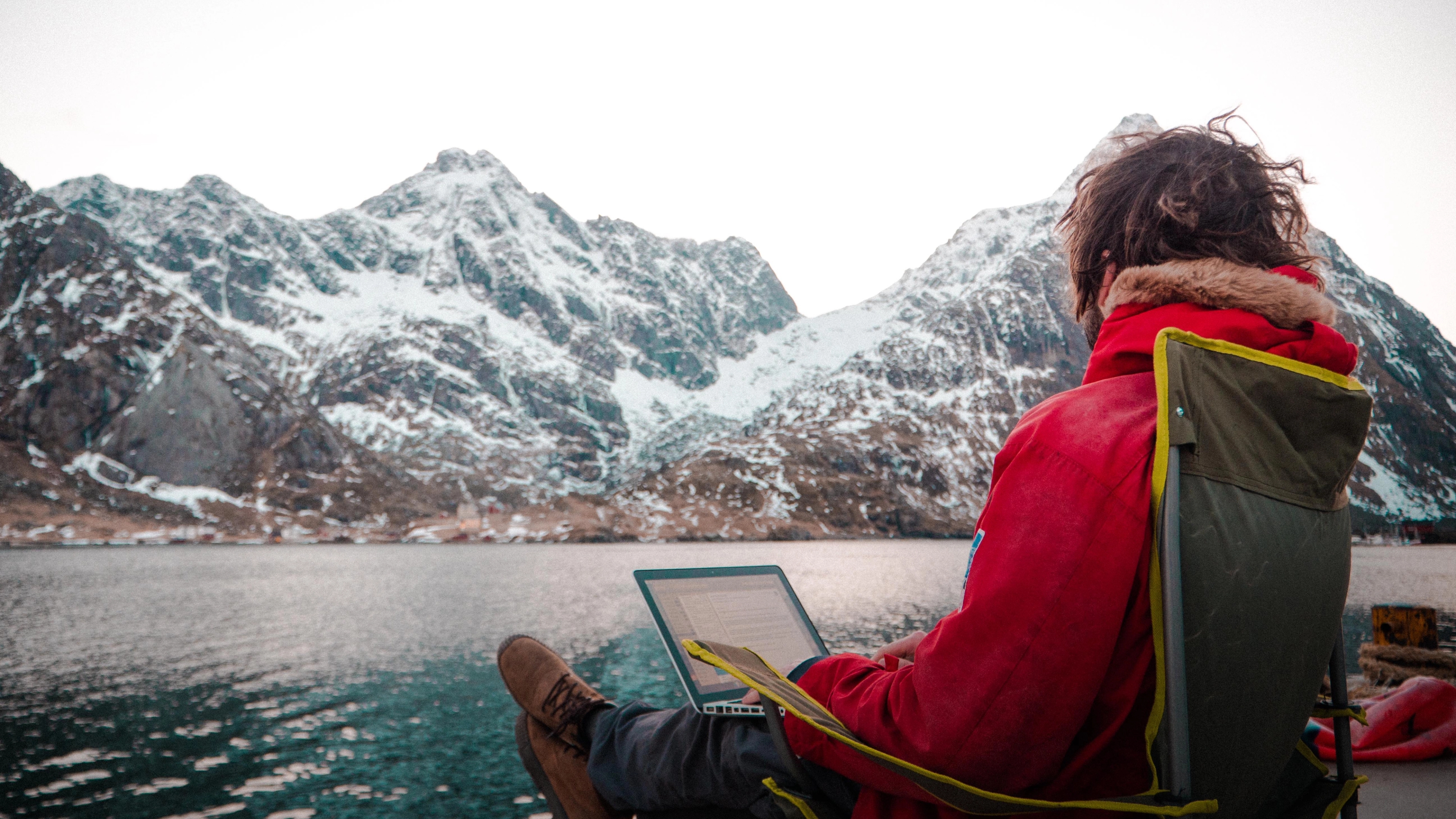 A man working outdoors by the sea at the Arctic Coworking Lodge in Lofoten, Northern Noway