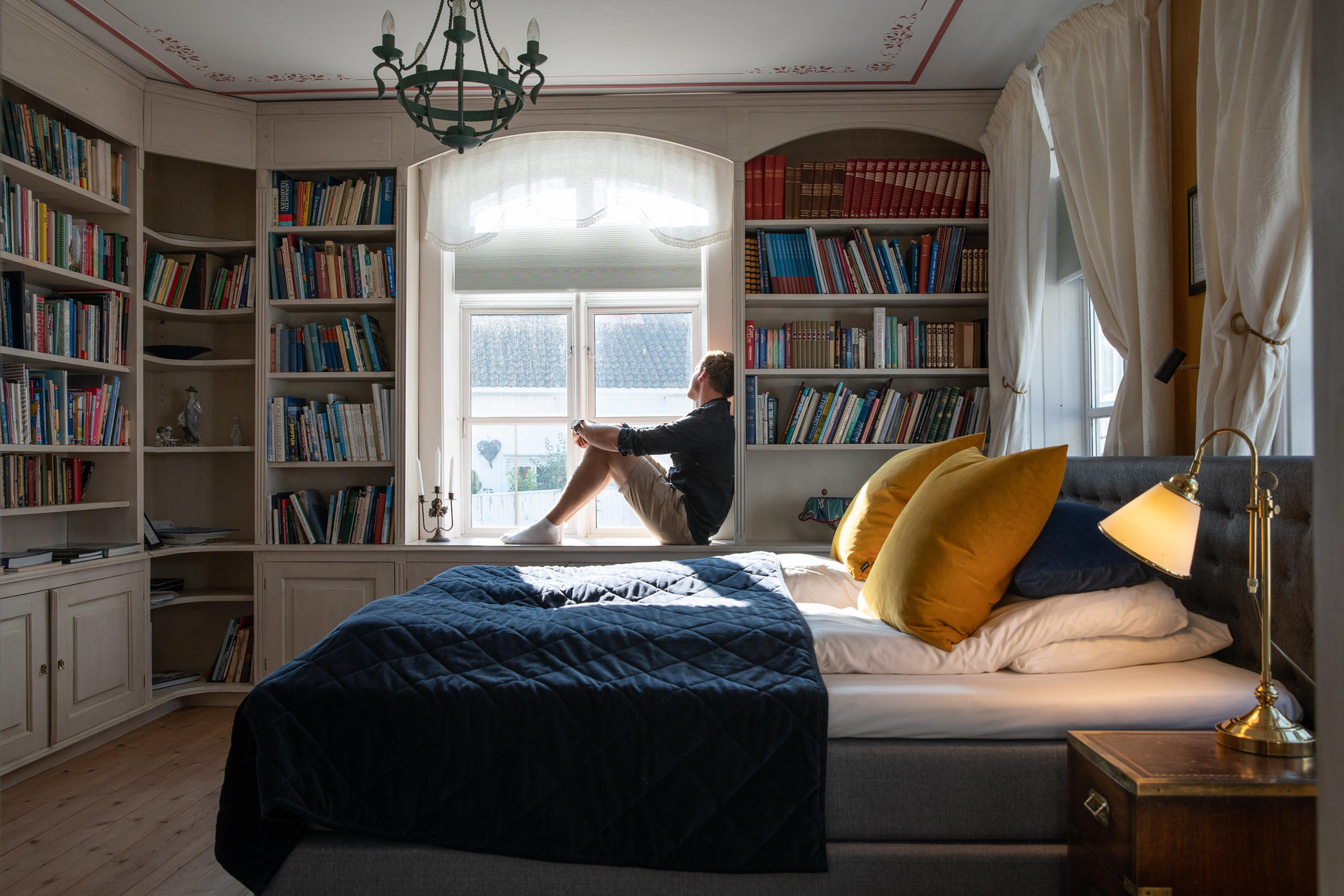A person sitting on a bed in Det lille hotel in Risør, Southern Norway