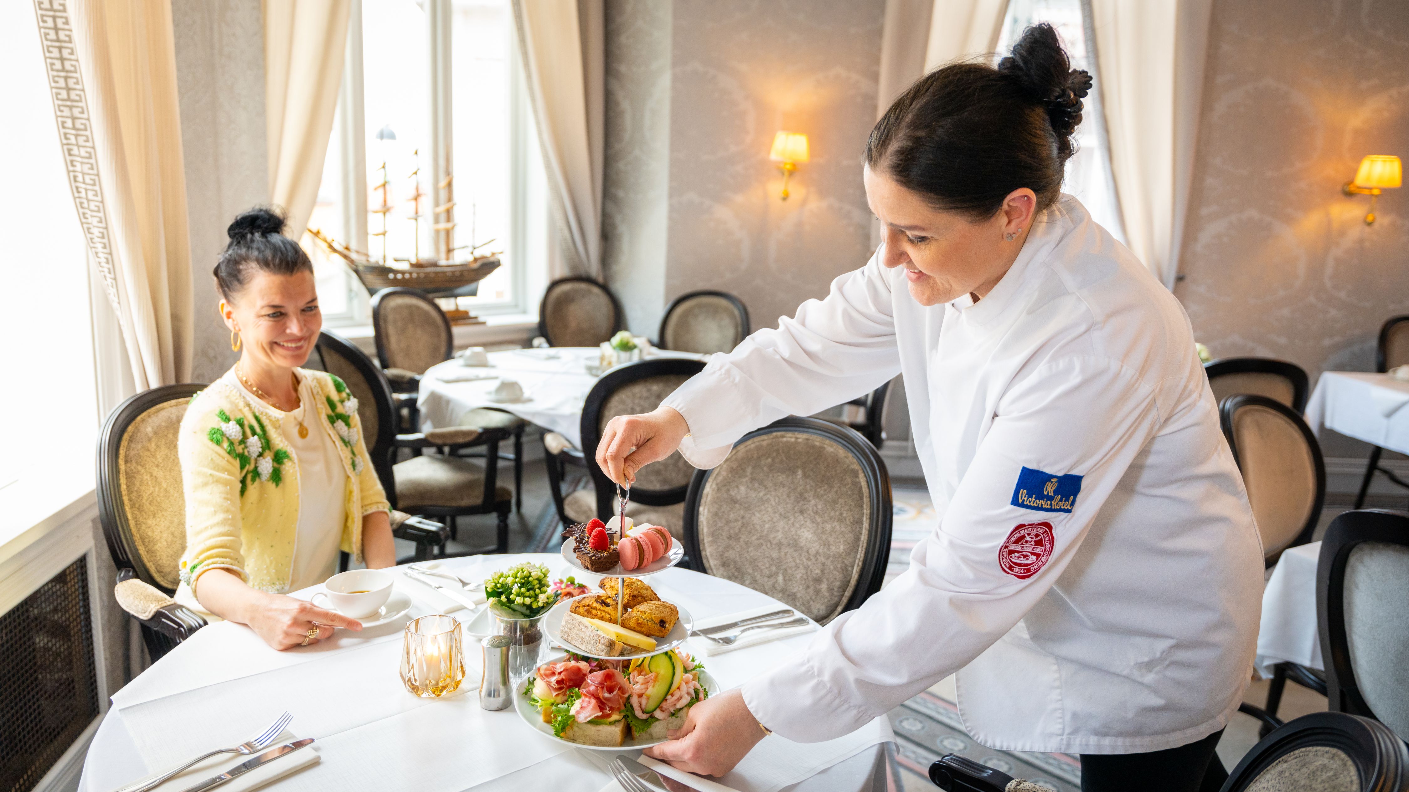 A women is being served a afternoon tea at Hotel Victoria in Stavanger, Fjord Norway