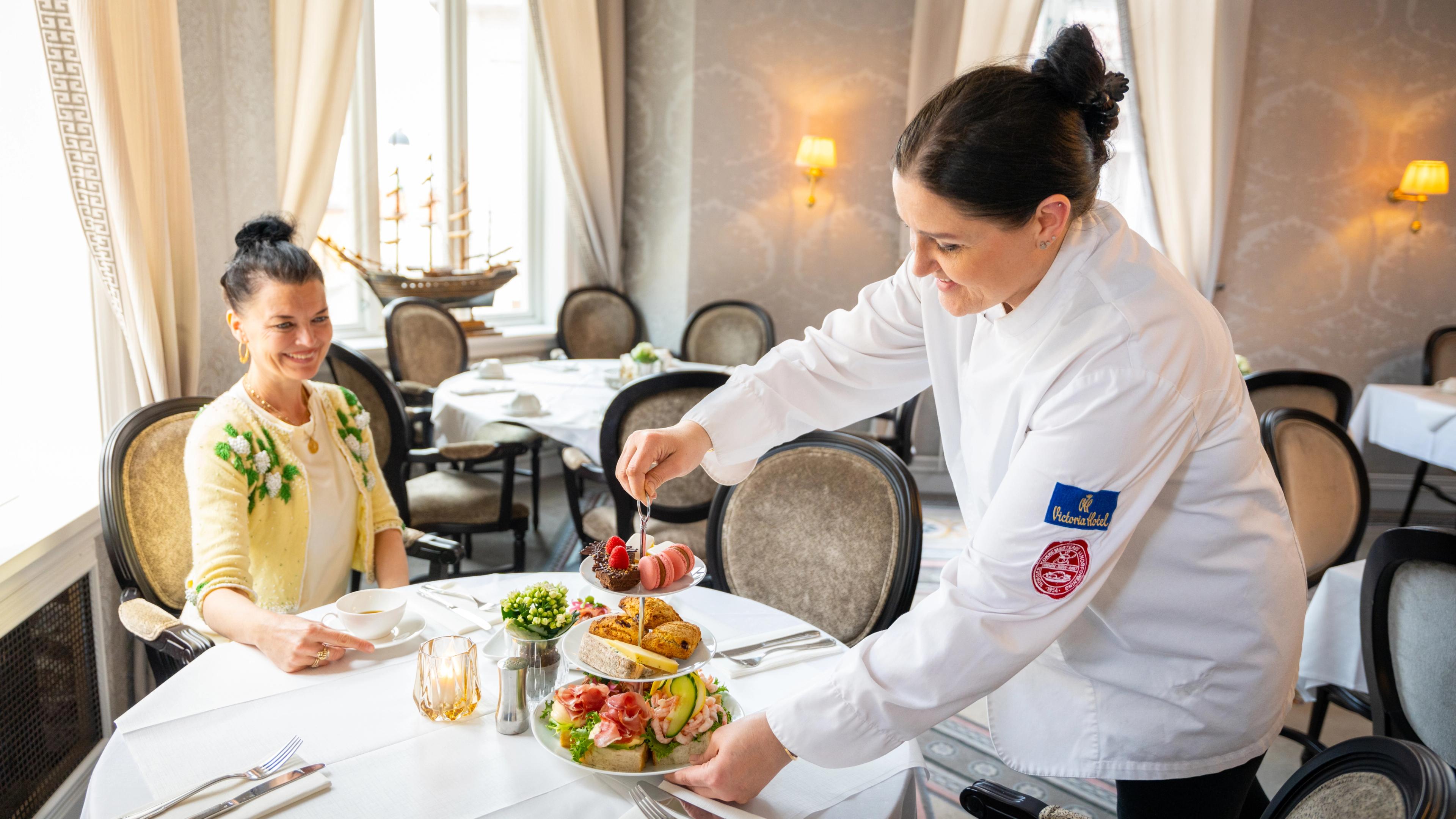 A women is being served a afternoon tea at Hotel Victoria in Stavanger, Fjord Norway