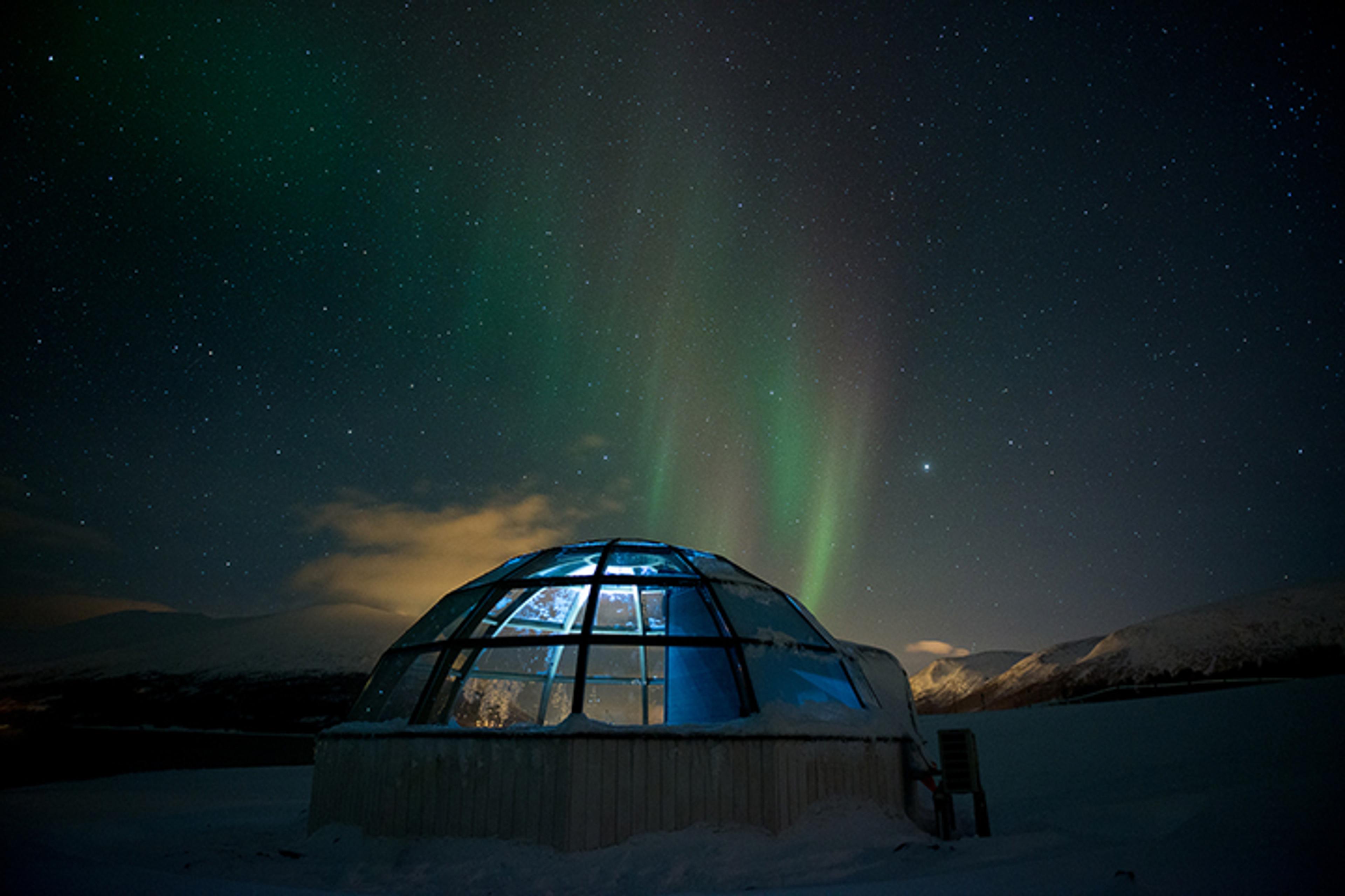 Glass igloo under the Northern Lights