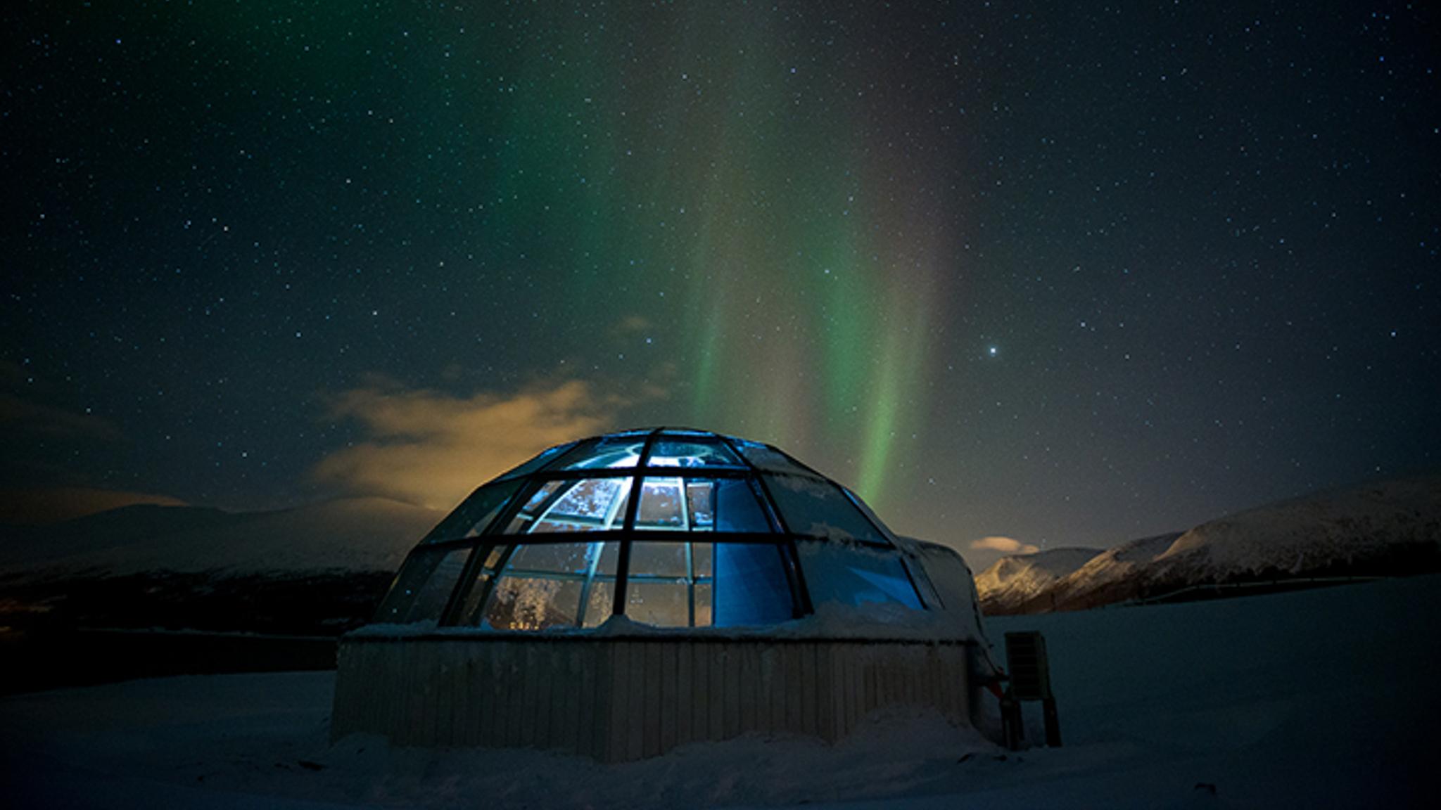 Glass igloo under the Northern Lights