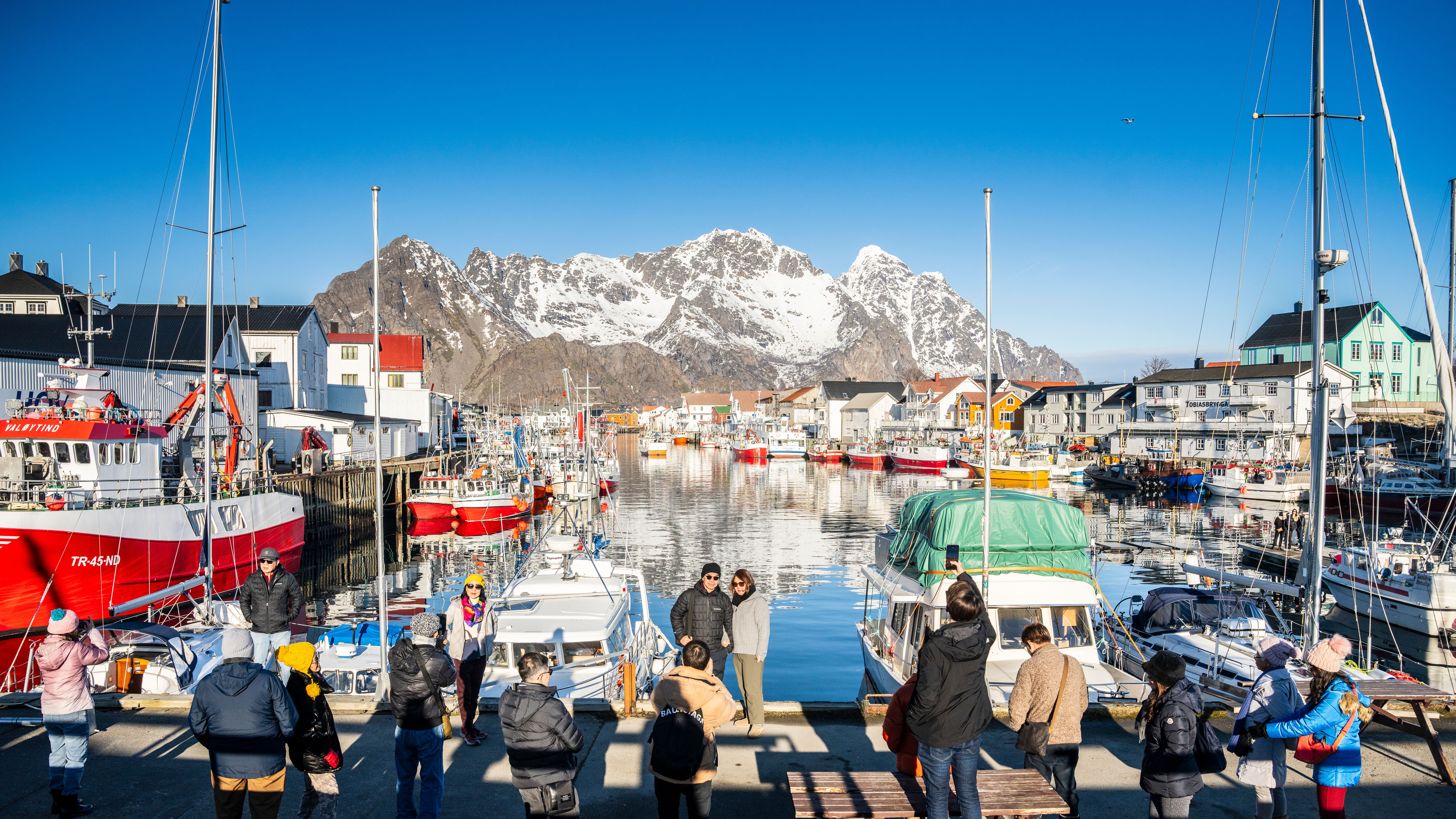 Tourists enjoying the view on the dock in Henningsvær